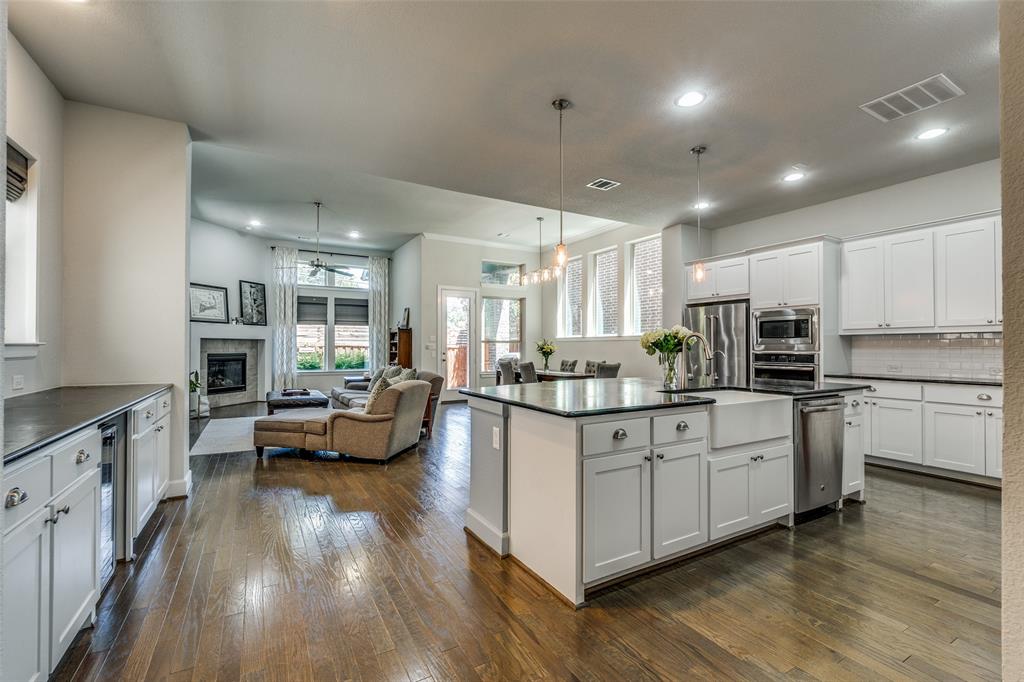 Don't miss this rare opportunity in the highly coveted, gated Villas of Lake Highlands, a community that truly sells itself with a private pool, park, and lush green spaces, all included in a maintenance-free lifestyle. From the moment you step inside, soaring ceilings and walls of windows flood the open-concept main level with natural light, creating an airy, magazine-worthy atmosphere that has to be seen in person. Rich hardwood floors flow through a chef's kitchen that checks every box, featuring an oversized center island, black soapstone countertops, crisp white cabinetry, subway tile backsplash, walk-in pantry, and breakfast bar seating, all opening seamlessly to the dining area, covered patio, and inviting living room anchored by a gas fireplace. What truly sets this home apart is what you won't find anywhere else: a primary suite with vaulted ceilings, a sitting area, and breathtaking treetop views with absolutely no two-story homes behind you, a privacy feature that is nearly impossible to find in this market. The spa bath, three additional bedrooms, flex office space, and dedicated laundry room complete a floor plan as practical as it is beautiful. Homes with this combination of location, lifestyle, and features don't come around often, and with proximity to Lake Highlands Elementary, top dining, shopping, and major commuter routes, this one deserves to be at the top of your list!