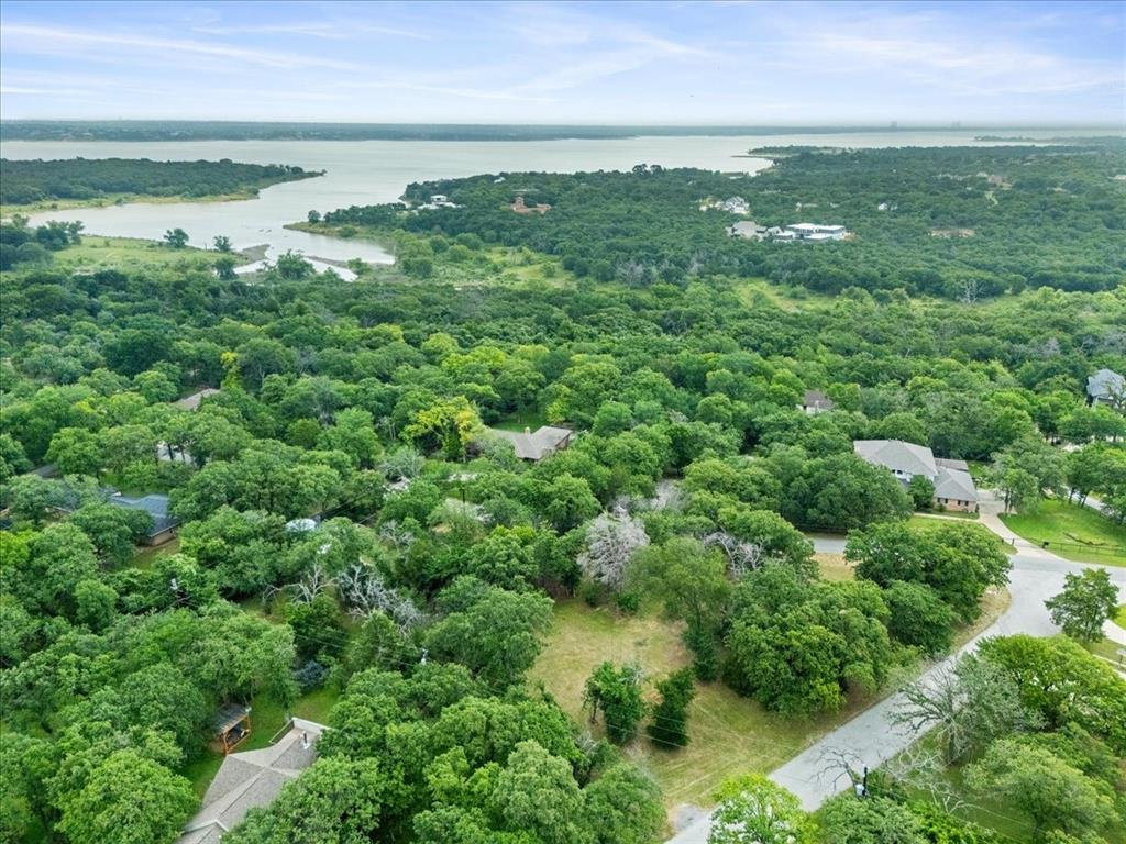 Rare Nearly 1-Acre Custom Luxury Homesite in Southlake  Carroll ISD  No HOA Restrictions Unmatched Location • Elevated Setting • Build-Ready Opportunity An extraordinary opportunity to design and build a legacy custom estate on one of the very few remaining large homesites in prestigious Southlake. Tucked within a serene, park-like setting just moments from Grapevine Lake, this exceptional property offers a rare blend of luxury, privacy, natural beauty, and convenience. Situated on a prominent 0.8934-acre corner lot, the property features a fully usable homesite surrounded by trees, creating the ideal canvas for an expansive luxury residence with seamless indoor-outdoor living. Its elevated position—among the highest points in the neighborhood-provides a commanding estate setting and may allow for potential lake views of Grapevine Lake from a thoughtfully designed multi-story custom home. With no HOA restrictions, buyers enjoy the freedom to build on their own timeline and bring their preferred architect and custom builder without restrictive oversight. Located entirely within the boundaries of the Carroll ISD , this property offers access to one of Texas' premier public educational institution. The previous residence has already been professionally removed, saving substantial demolition costs and valuable development time. Utilities are available onsite, making this a true build-ready opportunity for immediate planning and construction. Enjoy the tranquility of a private natural retreat while remaining just minutes from shopping and dining at Southlake Town Square, premier outdoor recreation at Bob Jones Nature Preserve and Grapevine Lake, and convenient access to DFW International Airport. Whether you are a discerning buyer envisioning a private architectural masterpiece or a custom builder seeking premier inventory in one of Texas’ most coveted luxury communities, this is an exceptionally rare offering with limitless potential.