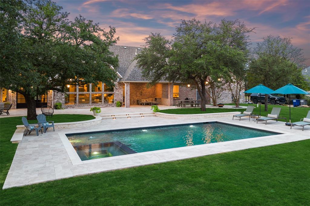 Nestled within the esteemed Gentle Creek Estates, this luxury pool home, envisioned by DISC Interiors, embodies refined living. Thoughtfully redesigned in 2022, this 5 bed, 4.5 bath home boasts the pinnacle of craftsmanship & design. Seamlessly blending traditional inspirations with modern sophistication, the architecture delivers purposeful spaces adorned with the finest finishes. From the grandeur of 13' iron doors to the elegance of 20' ceilings, every detail speaks of luxury. Level 5 walls, European white oak floors, reclaimed limestone, marble countertops, & rift-cut white oak cabinetry grace the interior alongside a custom library wall and a double-sided venetian plastered fireplace. Practicality meets elegance with California Closets, Monogram appliances, dual Bosch dishwashers, Kallista plumbing fixtures, and Emtek door knobs. Set on a sprawling 1.2+ acre lot adorned with trees, the property offers a new pool and an expansive 2600 sqft travertine patio. PreQual required to show
