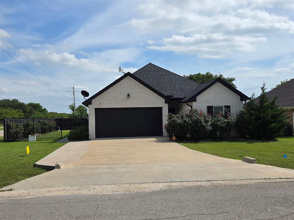 Barely lived in home on a corner lot next to the intermediary school! This home has vaulted living room ceiling with cedar wrapped beam, wooden accents walls, built in bookcases, and tile flooring throughout. You'll appreciate the split floor plan with isolated master suite featuring a large walk in closet. Low maintenance yard with wifi programmable sprinkler system and wooden privacy fence. Additional upgrades include an extended concrete back porch for gathering, seamless gutters with leaf guards, insulated garage door, and custom kitchen cabinetry. Minutes to I-35 makes it easy for metroplex commuters. Schedule your showing today!