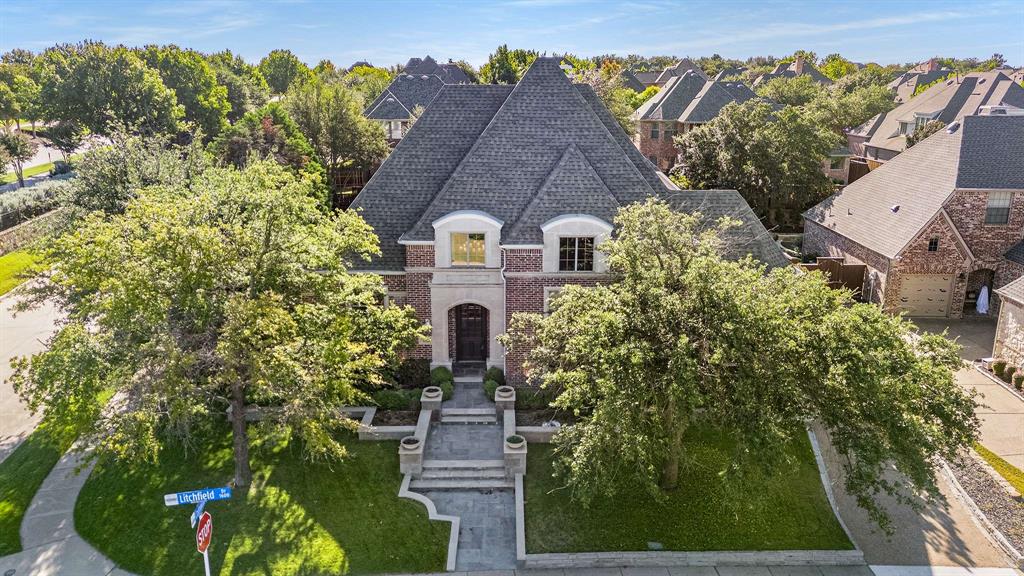 A masterpiece of custom craftsmanship awaits in this refined Huntington home. Hand-scraped hardwood floors guide you through an expansive, open-concept floor plan designed for modern lifestyles. The main floor offers a serene master suite, while three additional bedrooms provide spacious accommodations on the second level. Beyond, four distinct living areas provide versatile spaces for gathering, unwinding, and entertaining. The state-of-the-art kitchen is a culinary dream, appointed custom ash cabinetry, granite countertops, a large island, premium stainless steel appliances including a built-in refrigerator, double ovens, and a five-burner gas cooktop with downdraft ventilation.
The first-floor study captivates with a custom-milled ceiling and bespoke built-ins. A stunning stone fireplace serves as the centerpiece of the main living area, complemented by a seamless built-in media center. The master bath offers a tranquil, hydro-jetted tub for a private spa experience. For entertainment, a dedicated media room and game room are located on the second level. Thoughtful details include elegant plantation shutters, a convenient central vacuum system, Charger water softening system and a utility room with sink and separate entrance. Step outside to the covered patio to enjoy the privacy of the large backyard.  The pretty street appeal with cast stone includes a front yard boasts custom planters, zoisia and the drip irrigation.