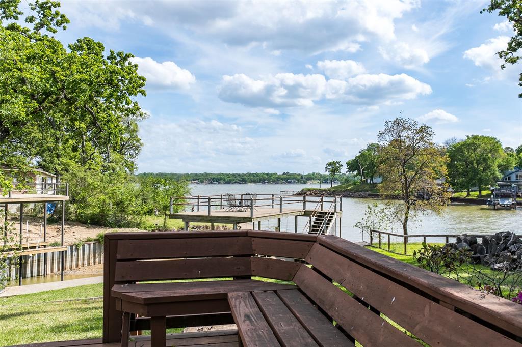 Perfectly positioned just off of open water, this charming 1,500 square foot lake home offers wide open water views year-round, the ideal blend of relaxed lakeside living and, convenient access to everything the area has to offer. This beautifully updated waterfront retreat is located in the highly sought-after Arnold Hills community on Cedar Creek Lake. Inside, you’ll find an inviting and thoughtfully refreshed interior featuring fresh paint, new carpet upstairs, and a spacious open-concept living area anchored by a cozy brick fireplace. The stylish galley kitchen showcases shaker cabinetry and leathered granite countertops, creating a functional and attractive space for everyday living or entertaining. With two primary suites—each offering stunning water views—this home is perfectly suited for hosting guests or multigenerational living. Step outside to experience true lakefront living. Enjoy year-round relaxation on the screened porch or entertain with ease on the expansive wood deck overlooking the water. The private boathouse with party deck invites endless days of boating, fishing, and sunset gatherings, while the shaded yard with mature trees enhances the tranquil setting. Located in the desirable Arnold Hills neighborhood, residents benefit from a welcoming lakeside community known for its friendliness, charm and accessibility. Just minutes away, the vibrant dining and entertainment scenes of Tool and Seven Points offer a variety of local restaurants, marinas, and nightlife, making it easy to enjoy the best of Cedar Creek Lake living both on and off the water. Whether you’re searching for a weekend getaway or a full-time residence, this lake home delivers an exceptional opportunity to own a slice of waterfront paradise in one of the lake’s most desirable communities.