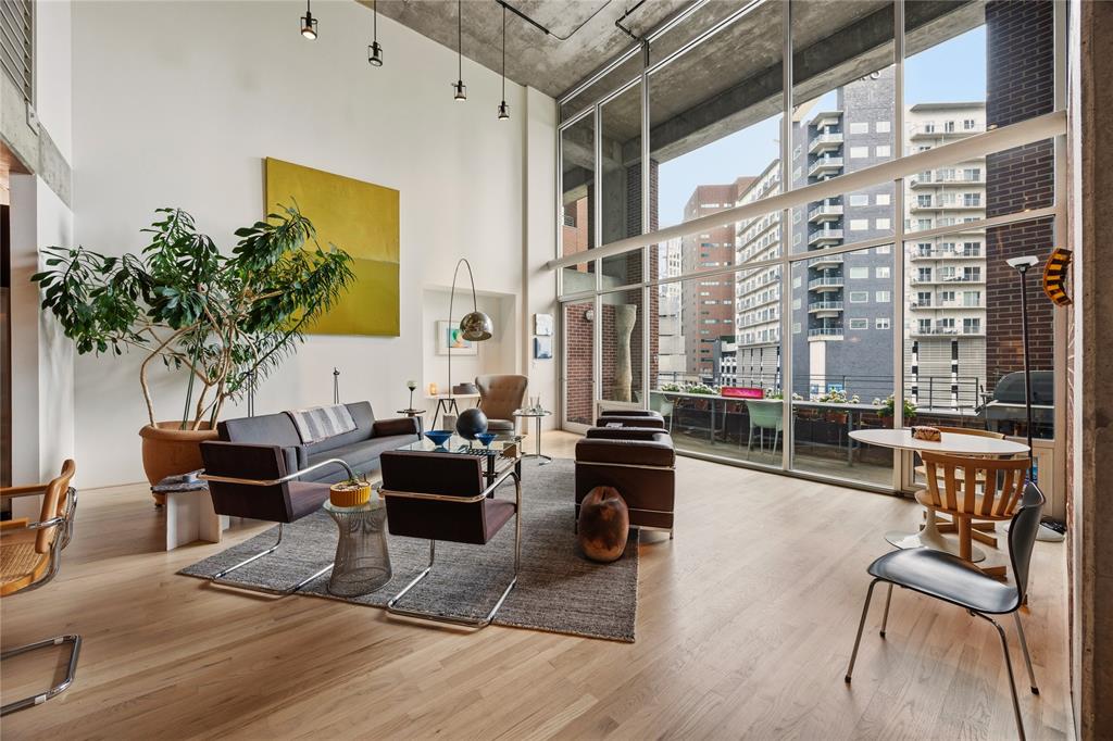 Experience true urban loft living in the heart of Uptown. Located in 2011 Cedar Springs, a boutique red-brick mid-rise, this striking contemporary residence offers 2,306 square feet of open living space highlighted by dramatic two-story windows that flood the home with natural light and showcase dynamic city views. The main level features natural white oak floors and an expansive living and dining area designed for both everyday comfort and entertaining. The modern kitchen with center island provides ample space for casual dining and meal prep. Just off the entry, a cozy library lounge (a potential second bedroom!) and full bath offers the perfect spot for reading, watching TV, or hosting overnight guests. Upstairs, the open loft-style offer overlooks the living space below. The sizable primary suite boasts a full wall of windows and includes a spacious bath and large closet. Laundry and additional storage round out the upstairs. Building amenities include a resort-style pool and outdoor lounging area with an outdoor kitchen, covered parking and a dog park. Enjoy an unbeatable, walkable location near some of Dallas’ most popular destinations, including American Airlines Center, Klyde Warren Park, the Katy Trail, and the Dallas Arts District. Plus you can enjoy the restaurants, nightlife, and entertainment of Victory Park and Uptown just steps away. Loft 305 combines architectural character, generous space, and an exceptional location for a sophisticated Uptown lifestyle.