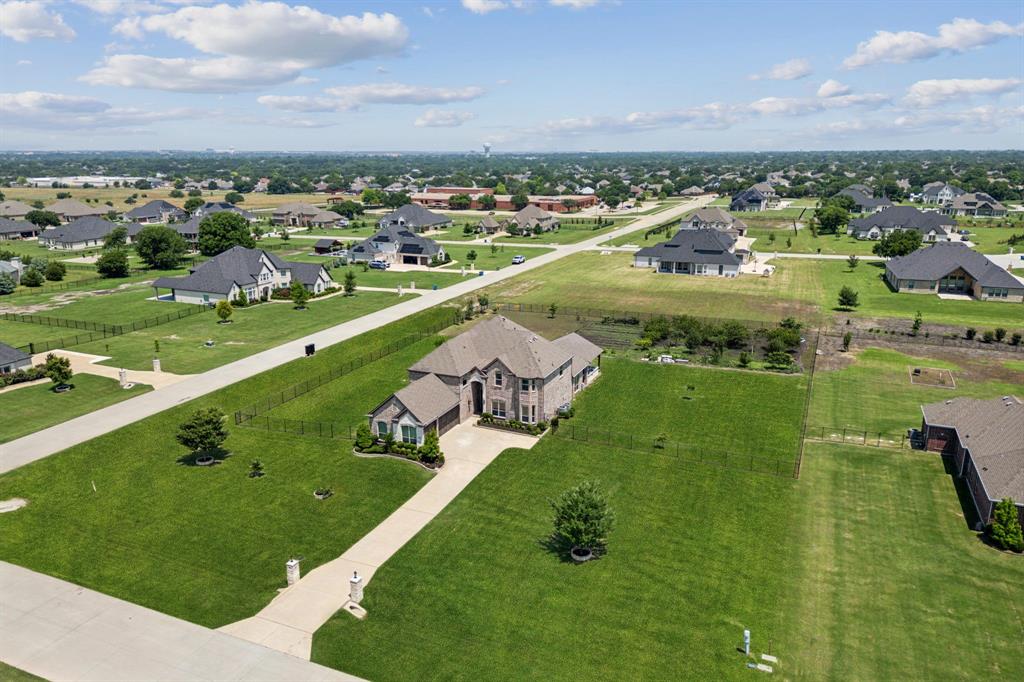 Welcome to this beautifully designed two-story home situated on a prime 1.5-acre corner lot. See the elementary school from your backyard in highly sought-after Allen ISD. This expansive residence offers 6 generously sized bedrooms, including both the primary suite and a second ensuite bedroom on the main floor—ideal for multigenerational living or guests. The second ensuite offers flexibility to serve as a convenient home office. Upstairs you'll find four additional bedrooms, a large game room, and a freshly painted media room perfect for movie nights. The heart of the home features an open-concept living area and an eat-in kitchen, complemented by separate formal dining and living rooms. Step outside onto the recently extended covered patio still under structural warranty. The fully equipped outdoor kitchen is ready for entertaining year-round. Your spacious backyard is fully fenced and the thriving garden is filled with a variety of fruits and vegetables. Additional highlights include a 3-car garage with epoxy flooring, plenty of storage, high ceilings and beautiful landscaping. Don't miss this rare opportunity to own a private retreat with room to grow!