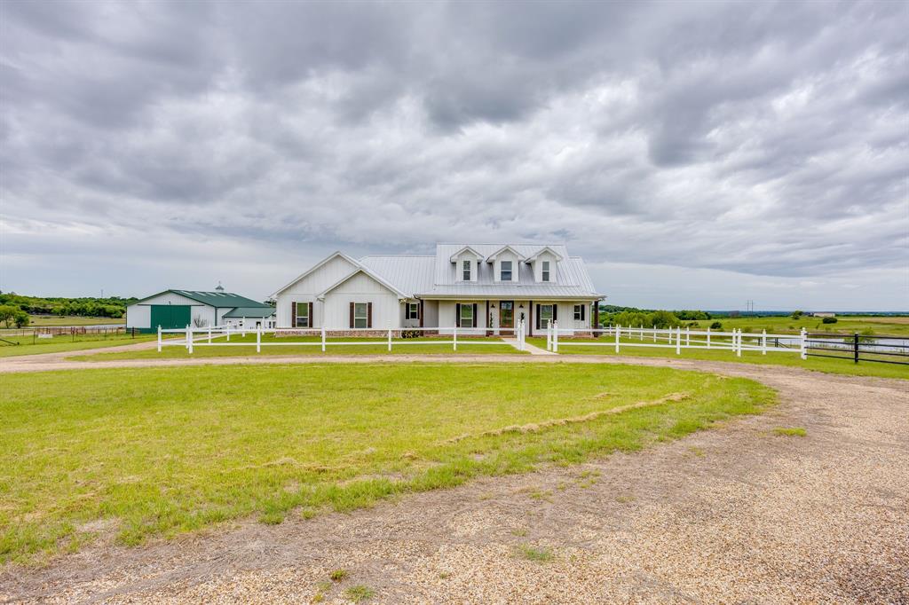 Set on 10+ breathtaking acres, this picturesque ranchette with 2 separate dwellings and a mother-in-law suite is thoughtfully designed for refined country living. The stunning main farmhouse with charming, covered porches offers 4 bedrooms, 4 bathrooms, 3 car garage, 2 private offices, and a media-game room… curated details throughout include: painted shiplap, a brick kitchen backsplash, stainless-steel countertops, lovely stained-glass accent doors, butler's pantry, and luxury outdoor kitchen. The attached mother-in-law suite with garage and private exterior access has its own kitchen, living area, bathroom, and walk-in closet - ideal for multigenerational living or guests. A large shop-barn with double sided oversized bay doors offers exceptional versatility that features an office space, loft storage, as well as a fully equipped barn apartment with a full kitchen, living room, bathroom, and utility room - perfect for ranch help, guests, or income potential. Behind the apartment is a conditioned space equipped with a pet washing station with a floor drain, doggy door, plenty of space to add kennels for keeping pets for your own use or for grooming or boarding. RV hookup on site as well. This rare turnkey ranchette with privacy, flexibility, and elevated amenities offers exceptional rural living. Additional 20 acres available next door.