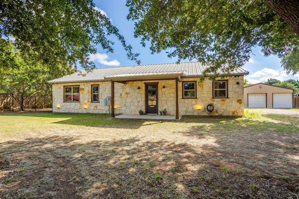 Nestled outside the Burleson city limits on .62 acres, this 1,800-square-foot limestone ranch-style home offers the perfect balance of country living and convenience, just minutes from shopping, dining, and everyday amenities. Inside, you’ll find concrete flooring, a gas fireplace with a limestone hearth, custom built-ins, and a kitchen featuring custom cabinetry with thoughtfully designed storage solutions. The private primary suite includes a steam shower, while the guest bathroom features an oversized clawfoot soaking tub. One of the secondary bedrooms is unlike any other, complete with custom climbing bunk beds and a hidden secret room, creating a fun and memorable space for kids. Step outside to a spacious 20x20 covered patio overlooking the backyard, where you’ll enjoy a garden space, nearly 20 native flowering plants, and several mature trees that provide beauty and shade. The outdoor children’s playset stays with the home, and the 30x30 shop with electricity offers excellent space for projects, storage, parking or hobbies. Also included are commercial-grade dog kennels that can double as predator proof chicken coops and a trough pool for the kids, pets, or to cool off after work. With its custom features, functional spaces, and peaceful setting, this property offers a rare opportunity to enjoy the charm of country living with the convenience of city life just minutes away. Worth mentioning, this home is located in the desired Joshua ISD school zone.