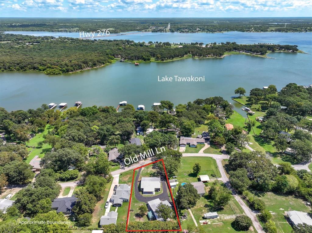 Lake Tawakoni views from this completely 2025 remodeled home with a shop in a well-kept neighborhood of Whispering Oaks! Austin stone front, easy to maintain metal exterior, metal roof on a large .40 acre lot.  Sit on the gorgeous, landscaped and raised 500 SF covered front porch and enjoy the views of the lake! Open concept home with private master suite on one side of the home with entry to porch. Primary suite is large with large walk-in closet, ensuite bath with soaker tub, dual sinks and separate tiled shower. Kitchen has been beautifully updated and remodeled with butcher block counters, custom cabinets and 2025 SS appliances. Large utility room has room for other appliances. Guest bedrooms share a remodeled guest bath with tiled tub shower. Guest bedroom #2 has its own entry onto the porch. There is plenty of covered parking, new asphalt circle driveway makes a horseshoe around the back of the home and in front of the 50x30 shop with upstairs loft! Park you truck and boat in the boat area of the shop.  Additional covered concrete parking behind the shop for more equipment and toys! Greenhouse. Rains ISD!  Community boat ramp and no HOA! Lake life awaits! Back on the market at no fault of the seller!