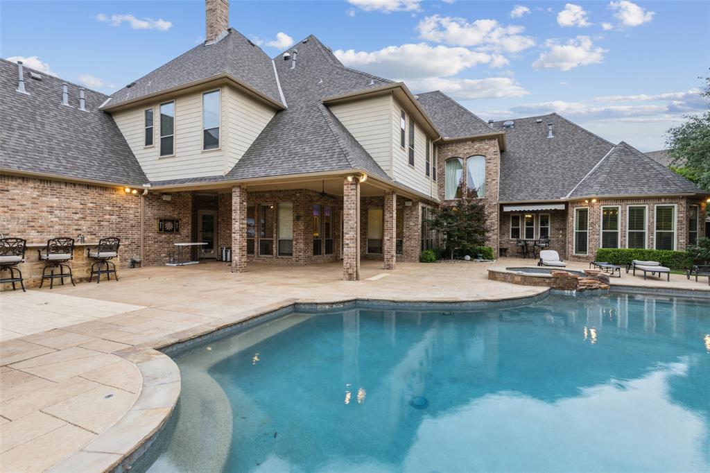 Discover refined living in this exceptional estate, nestled on a quiet cul-de-sac in the prestigious Timarron – Eagle Bend Estates. Perfectly positioned within award-winning Carroll ISD, this Southlake residence combines timeless elegance, modern convenience, and an unbeatable location. Set on a half-acre lot, the home spans 6,729 square feet with 7 bedrooms, 7 full baths, and 3 half baths—designed to accommodate both intimate living and grand entertaining. The dramatic two-story foyer with sweeping staircase sets a stunning first impression, flowing seamlessly into light-filled living and dining spaces with rich architectural details. The chef’s kitchen is a true centerpiece, showcasing quartzite countertops, a spacious island, induction cooktop, commercial vent, built-in refrigerator, butler’s pantry, and walk-in pantry—perfectly suited for gatherings large or small. The primary suite offers a private sanctuary with its own sitting area, spa-inspired bath, oversized walk-in shower, soaking tub, and custom closets. Six additional ensuite bedrooms provide comfort and privacy for family and guests alike. Additional highlights include a dedicated media room, private office, dual staircases, plantation shutters, hardwood flooring, surround sound wiring, decorative lighting, and smart home features. Step outdoors to your backyard retreat, complete with a covered patio, outdoor kitchen, sparkling pool, spa, and a large grassy area ideal for play or pets. The oversized 3-car garage provides abundant storage plus a dedicated gym space. Beyond your doorstep, enjoy Timarron’s resort-style amenities—clubhouse, tennis courts, community pool, trails, parks, and a scenic lake. Just minutes from Southlake Town Square, golf, and dining, this residence offers a lifestyle of convenience and luxury.  Schedule your home tour today!
