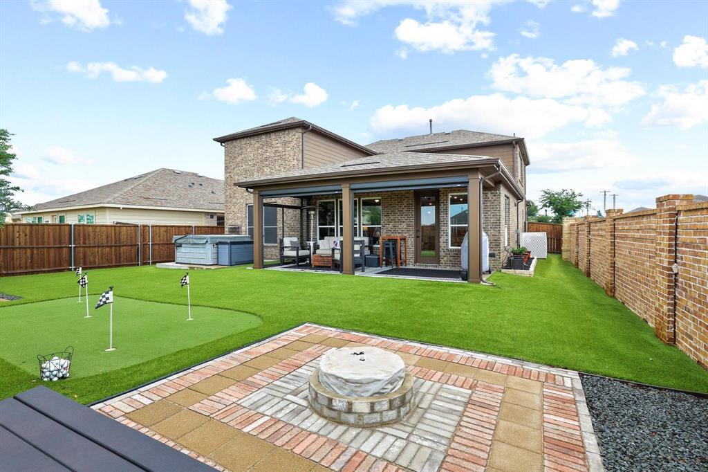 Rare opportunity to own a spacious corner-lot home in the highly sought-after Winn Ridge community! Built in 2020, this thoughtfully designed 4-bedroom, 2.5-bath home offers nearly 3,000 square feet of living space and features one of its most desirable highlights—an oversized media room, a feature many homes simply do not offer, perfect for movie nights, gaming, sports viewing, or creating the ultimate home theater experience. The highly functional floor plan includes a private primary suite downstairs, a dedicated office that can also serve as a playroom, study, or flex space, multiple walk-in closets throughout, and an open-concept kitchen and living area designed for everyday living and entertaining. Upstairs, you'll find the impressive media room, a separate game room, three additional bedrooms, and a full bath, providing exceptional flexibility for families of all sizes. Step outside to enjoy an extended covered patio with motorized shades, a fully turfed backyard, private putting green, and dedicated fire pit area—creating a low-maintenance outdoor retreat built for entertaining. Additional upgrades include insulated interior walls for enhanced privacy and sound reduction. Located on a desirable corner lot and just a short walk from Winn Ridge's resort-style amenities, including pools, pickleball courts, playgrounds, and walking trails, this home combines space, functionality, and lifestyle with convenient access to Hwy 380, shopping, dining, and Denton ISD schools.