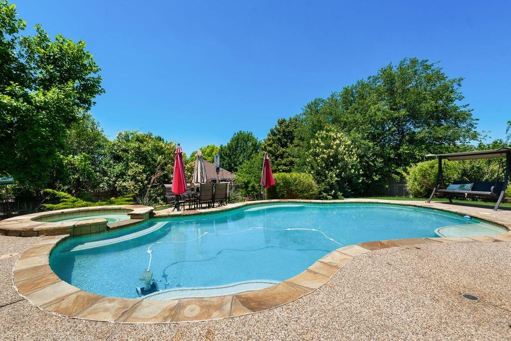 Beautifully maintained one-owner home offering 5 bedrooms, 2.5 baths, and a thoughtfully designed floorplan in a sought-after Fort Worth location. The downstairs features a spacious primary suite with a private ensuite bath, a dedicated office perfect for working from home, and an open-concept layout ideal for everyday living and entertaining. The expansive kitchen offers abundant quartz counters, storage, and room to gather, all flowing seamlessly into the living area showcasing custom built-ins, a cozy fireplace, and a stunning wall of windows overlooking the backyard retreat. Step outside to enjoy the beautiful covered patio, extended pergola, and sparkling pool with attached spa — the perfect setup for relaxing or entertaining year-round. Upstairs you’ll find a large loft-style game room, dedicated media room with equipment, and 4 generously sized secondary bedrooms with a shared bath. Thoughtfully designed and truly move-in ready, this home combines space, comfort, and convenience. Additional features include garage shelving that will convey with the property, providing excellent storage and organization. Located in Eagle Mountain-Saginaw ISD with easy access to shopping, dining, parks, and major highways. A great opportunity in a well-established neighborhood—don’t miss this one!