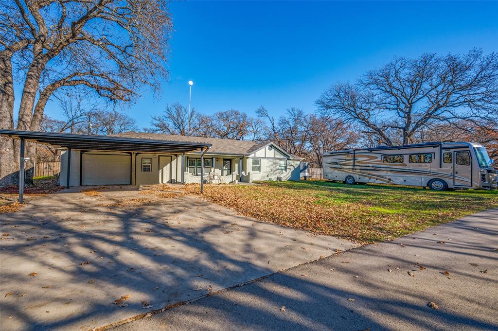 Updated Charmer minutes from Eagle Mountain Lake with shared boat dock access boasts RV Parking, 3 Additional Covered Parking & 3 Living Areas! The 18x9 open courtyard welcomes you into this freshly painted home home w all new tile flooring throughout. Possibilities are endless with the three flex living areas. 1st has a bay window, 2nd off the kitchen can serve as a formal dining or large casual living space, 3rd inside converted garage can serve as a media room or study. The charming kitchen has stainless appliances, a restaurant-grade garbage disposal, cookbook storage, 3 cm granite counters, and beadboard ceilings. The primary suite has a large closet and remodeled ensuite bath with shower-tub combo, medicine cabinet & new heat lamp. Secondary beds are spacious with built-in desk areas, large closets & direct access to the remodeled full bath with custom vanity, shower-tub combo & new heat lamp. Backyard finds a 14x12 covered patio, trumpet vines & lots of trees. Owners upgraded many windows with an easy clean feature, the tankless H2O heater, 2016 HVAC, & 2016 Roof. New blinds. New fixtures.