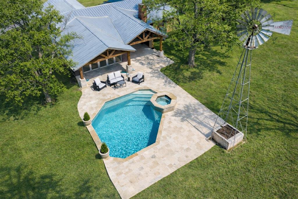 This stunning remodeled 3-bedroom, 2-bathroom custom home offers approximately 2,811 sq. ft. of thoughtfully designed living space, featuring rich wood floors throughout the bedrooms, hallways, living, dining, and kitchen. Nestled on 25 rolling acres just outside city limits, this property provides privacy, space, and breathtaking views. The home boasts an oversized 2-car attached garage, a newer pool and hot tub, and a fully fenced backyard—perfect for pets or children. Designed for both comfort and function, the property includes a 24' x 25' insulated workshop with a 24' x 25' lean-to,  24' x 50' hay storage and horse shelter in front pasture. The land is dotted with mature trees, offering shade and beauty, while the open pastures, wooded areas, and two stocked ponds make it ideal for ranching, hunting, or equestrian activities. A working windmill that sits by the pool, and a storm shelter provides peace of mind. With plenty of room for an arena and show barn, this incredible property offers endless possibilities for those looking for a rural retreat with all the modern amenities. Don't miss this rare opportunity to own a piece of Texas countryside with stunning views and unmatched potential! With Highway 82 frontage, ample acreage, and no city restrictions, this property is well suited for an equestrian estate, training facility, hobby ranch, or private country retreat in a highly desirable North Texas location. Opportunities like this are limited—schedule your private showing today to fully experience the land, views, and equestrian potential this property offers.