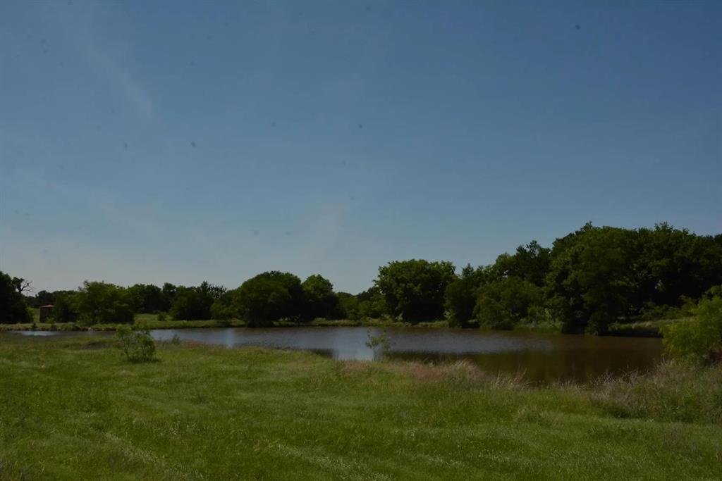 Rare opportunity to own 85 stunning acres overlooking the Bridgeport Country Club in Wise County, Texas. This elevated hilltop ranch delivers panoramic sunrise and sunset views, mature hardwoods, three stocked ponds, and abundant wildlife — all fully game-fenced with 8-foot fencing. The move-in ready 40x80 barndominium features full living quarters, a spacious kitchen, multiple bedrooms, and two bathrooms — perfect as a primary residence, hunting lodge, or weekend retreat. Improved Bermuda grass pastures, barn and corral facilities, and a turnkey cattle setup make this a true working ranch from day one. Water and electric already in place offer outstanding future development potential in one of the region's fastest-growing corridors. Direct access from FM 2123 and Country Club Road puts you just 3 minutes from downtown Bridgeport and approximately 55 minutes from Fort Worth. Whether you're looking for a private ranch, recreational escape, cattle operation, or long-term investment — this property checks every box.
