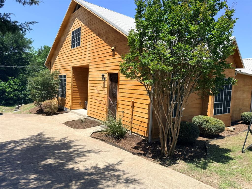 Custom-built, single-owner home on 1.47 acres offering privacy, space, and distinctive design just ~30 minutes from Dallas and ~11 minutes from Waxahachie's shopping. Built in 2010, this 3 bedroom, 2bath, 2,088 SF side entry residence is anything but cookie cutter crafted with attention to detail and a grand, open feel throughout, and includes a 1500 sf shop with separate living quarters.

The striking A frame living room features 20’ vaulted cedar ceilings and expansive windows that fill the space with natural light. A statement wood burning stove anchors the room, while custom French doors open to a 20’ x 20’ covered porch with matching cedar ceiling, perfect for seamless indoor outdoor living.

Inside, you’ll find 10’ ceilings, oversized 8’ solid-core wood doors, granite countertops, solid wood cabinetry, custom wall textures, and 2” faux wood blinds and ceiling fans throughout. The spacious primary suite offers a true retreat with a luxurious bath featuring a tub-in-shower design, multiple shower heads, double vanity, and LED mirror, along with custom built-ins in the oversized walk-in closet.

Secondary bedrooms are generously sized and connected by a Jack and Jill bath with a large soaking tub shower. A huge mudroom, laundry room includes a convenient pet washing station.

All new appliances convey. HVAC replaced in 2025. Home plumbed for gas as an option.

Step outside to enjoy wooded views, mature trees, and a peaceful creek, pond backdrop. A circle driveway adds convenience, and the property is located outside city limits for lower taxes. Wired for High speed fiber internet.

The 1,500 SF shop provides exceptional flexibility and includes an approximately 660 SF private guest suite with living room, bedroom, kitchen, bath, washer, dryer, separate septic, and its own electric meter, ideal for guests, multigenerational living, or private quarters.

Owner is Broker and Listing agent.