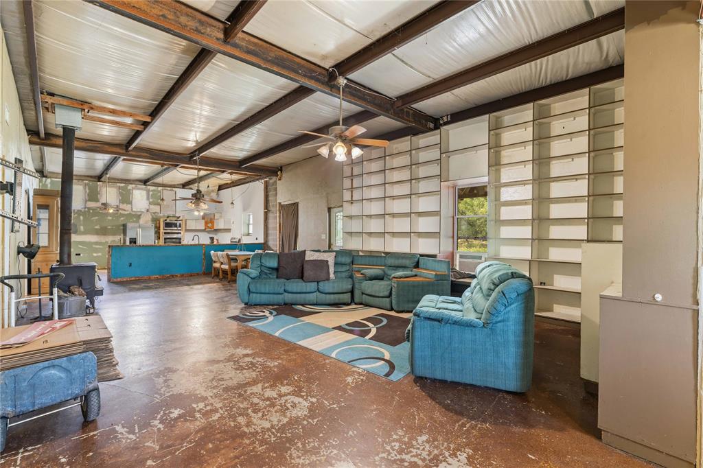Spacious 5 bedroom, 3 bathroom barndominium situated on a small acreage just minutes from town. This open concept home features a large family living area that flows seamlessly into the dining and kitchen spaces, creating an ideal setting for everyday living and entertaining. The home offers spacious bedrooms, an office space, a separate laundry room, additional storage, and plenty of room for a growing family. Enjoy the peaceful surroundings from the wraparound porch that extends along three sides of the home. Located on a secluded county road, this property provides the privacy of country living while remaining conveniently close to schools, hospitals, emergency services, shopping, dining, and other local amenities. The acreage offers flexibility for livestock and other agricultural pursuits. The home does need some updates , and the price reflects the opportunity for improvements to make it your own . Solar panels do not convey with the sale.
