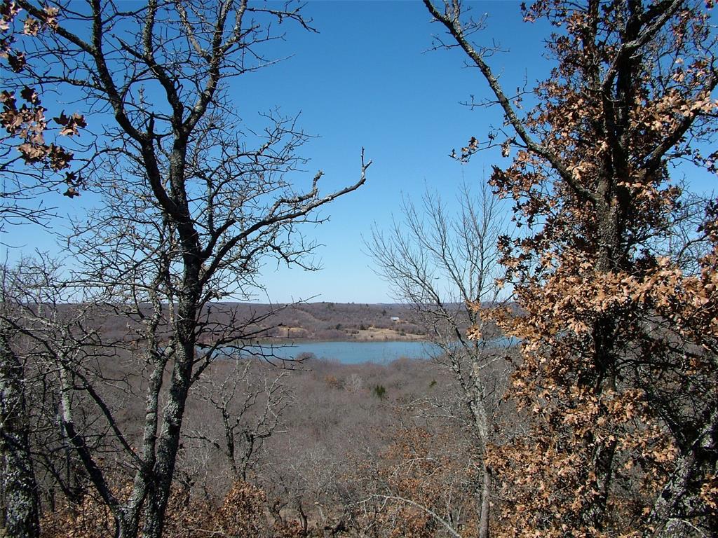 Discover your dream home site with this stunning 2-acre wooded lot perched high on a hill overlooking the serene beauty of Amon Carter Lake. Nestled at the end of a quiet cul-de-sac, this property offers unmatched privacy, tranquility, and breathtaking panoramic views of the water below. Imagine designing your custom home surrounded by nature, giant moss covered boulders and beautiful trees, where you can wake up to the sound of birdsong and enjoy peaceful evenings under the stars. With it's unique combination of seclusion and proximity to the lake, this lot is the perfect canvas for your private retreat or forever home. Don't miss this rare opportunity to own a slice of paradise.