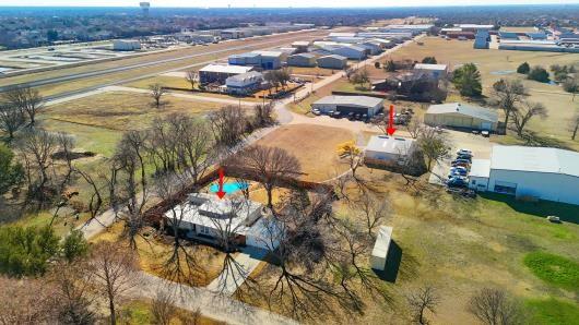 Located in an exclusive private airpark, this stunning 2,028-square-foot home offers three bedrooms and two baths, including dual primary suites with ensuite bathrooms. The open-concept floor plan flows effortlessly into a private backyard sanctuary—ideal for relaxing after a day in the skies or entertaining fellow aviators. Just steps away, the impressive 2,600-square-foot detached hangar is built for both function and flexibility. In addition to generous aircraft space—accommodating up to four planes with a Hangar door that is 12' Tall x 43' wide—it features a newly constructed, thoughtfully designed two-bedroom, one-bath accessory dwelling unit (ADU). Perfect for family, guests, a private office, or potential income-producing opportunities.