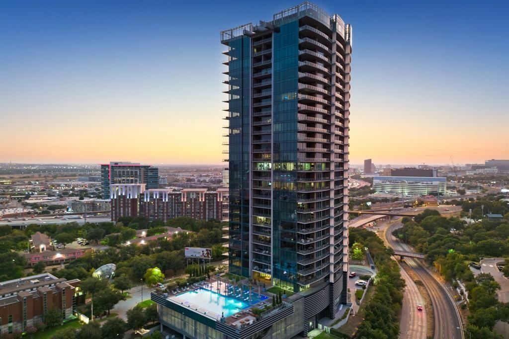 Suspended high above the Harwood District, this extraordinary and meticulously maintained home at the Bleu Ciel residence is a study in refined sky-rise living, where floor-to-ceiling glass frames uninterrupted views of the Dallas skyline from every vantage point. A sweeping wraparound terrace, anchored by a sculptural outdoor fireplace and curated seating vignettes, offers a rare private sanctuary in the clouds, ideal for both quiet evenings and elegant entertaining. Within, the open-concept living spaces are bathed in natural light, the city skyline serving as an ever-changing work of art beyond the glass. A statement kitchen showcases bespoke Porcelanosa cabinetry, honed marble countertops, a fully integrated Miele appliance suite, and a sculptural island that anchors the space. The primary suite evokes the indulgence of a five-star hotel: panoramic skyline views, a generously scaled layout, a tailored custom California Closet system, and a spa-inspired bath appointed with a freestanding soaking tub, oversized marble shower, and illuminated niche detailing, creating a private wellness sanctuary in every sense. Wide-plank hardwood floors, designer finishes and more than $100,000 in thoughtful upgrades imbue every room with a quiet, considered luxury. Residents of Bleu Ciel enjoy a world-class collection of amenities, including a junior Olympic pool with private cabanas and a poolside chef’s kitchen, a full-service spa, a private wine lounge with personal storage, two boardrooms with state-of-the-art AV, a contemporary library lounge, private garages, an advanced fitness and yoga center, a dedicated pet park, and 24-hour valet and concierge service. This is sky-rise living at its most exceptional, where privacy, panoramic beauty, and effortless luxury converge in one truly singular home.