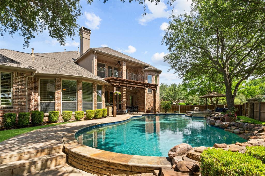 This stunning Huntington home boasts timeless curb appeal with an elegant brick and stone elevation, perfectly positioned on a beautifully landscaped corner lot with a private backyard oasis. Inside, a grand entry welcomes you with rich hardwood flooring that flows throughout the main living spaces, setting the tone for the home’s sophisticated design.  Thoughtfully crafted for both upscale entertaining and everyday comfort, the home features formal living and dining rooms, along with a private executive study complete with custom wood built-ins and coffered ceilings. The gourmet kitchen is a true showpiece, offering a built-in Sub-Zero refrigerator, commercial-grade 6-burner WOLF gas range, oversized island, and seamless flow into the spacious family room anchored by a warm fireplace.  Privately tucked away, the luxurious primary suite offers room for a sitting area and tranquil views of the backyard retreat. The spa-inspired bath features dual vanities, a soaking tub, separate walk-in shower, and an expansive custom closet with built-in dresser. A secluded guest or mother-in-law suite with full bath is ideally located at the front of the home.  Upstairs, you’ll find three generously sized secondary bedrooms, a versatile flex space, media room, and an entertainer’s wet bar complete with beverage fridge. A private balcony provides the perfect additional retreat to relax and unwind.  Outdoor living is equally exceptional with a covered patio, built-in grill, sparkling pool and spa, and ample grassy space for play or pets.  Located within the highly acclaimed Frisco ISD and the coveted master-planned community of Stonebridge Ranch, residents enjoy premier amenities and convenient access to major highways, shopping, dining, and entertainment.