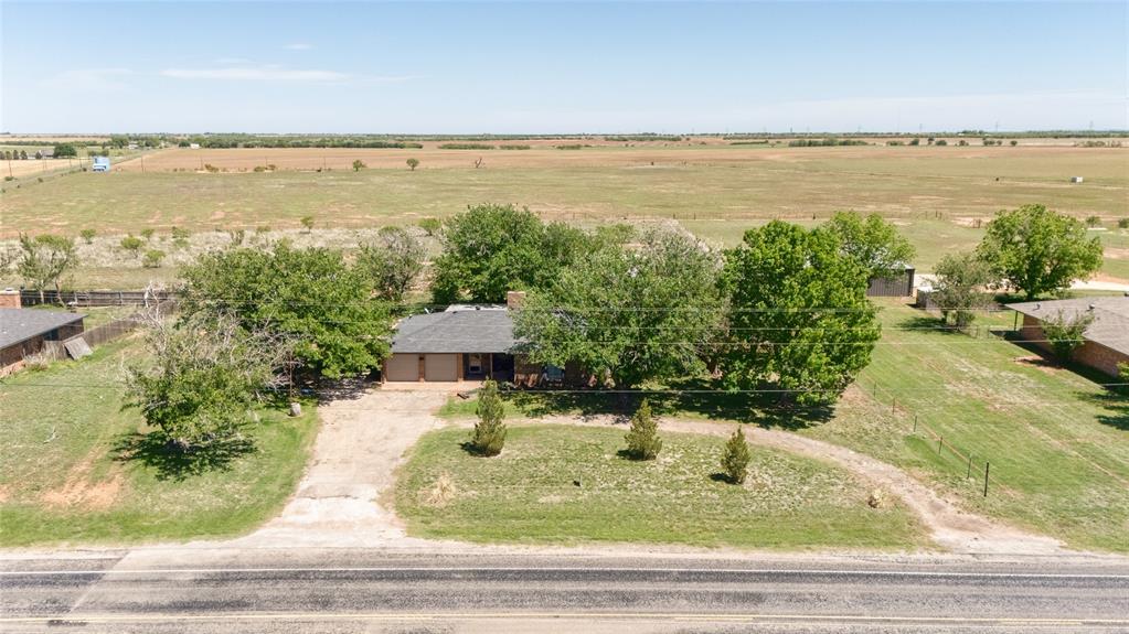 Owner is a licensed REALTOR®. Situated on approximately 2 acres in Merkel, this property offers a blend of open space and functional improvements with convenient access to Abilene. The home features new carpet throughout and a layout designed for everyday comfort. The acreage is enhanced by mature trees and a layout that provides space to spread out and utilize the land in a variety of ways. A metal RV cover offers dedicated space for RV parking or equipment storage. A standout feature is the 1000 sq ft insulated workshop, designed with two separate rooms, creating flexible space for projects, storage, or work areas. This property combines usable land, established improvements, and accessibility, making it a versatile option for a range of needs.