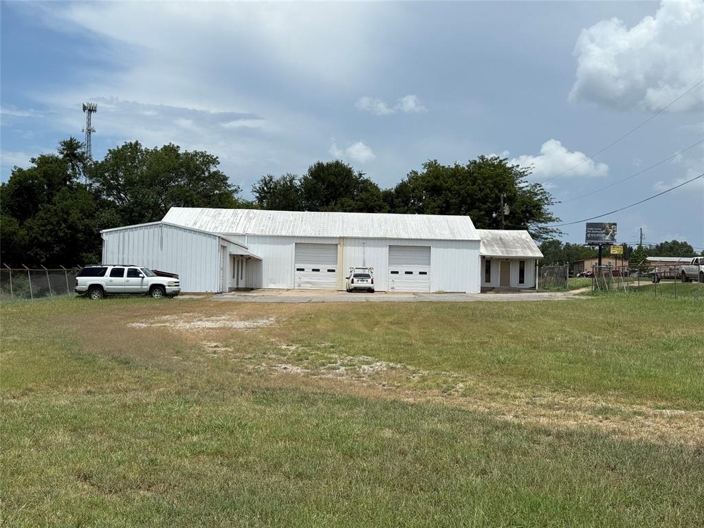This was a Family owned business for many years until retirement. Property has Great Access and visibility on Highway 121 and access on W 7th Street. Property features include work shops with overhead doors connected with a pass through door. One office is near the highway with 4 separate offices and 2 half baths. The other office on west side also includes a half bath. West office has a connected living quarters complete with Living area, Dining area, Kitchen, Laundry room, down stairs walk in shower and commode. The living quarters also includes a loft bedroom with full bath and walk in closet. Outside is a Large Fences yard with 2 culverts onto Highway 121 and the property extends south to West 7th and West to Willow Wild Cemetery Property. Many Options for business use and Property will be cleaned out before closing.