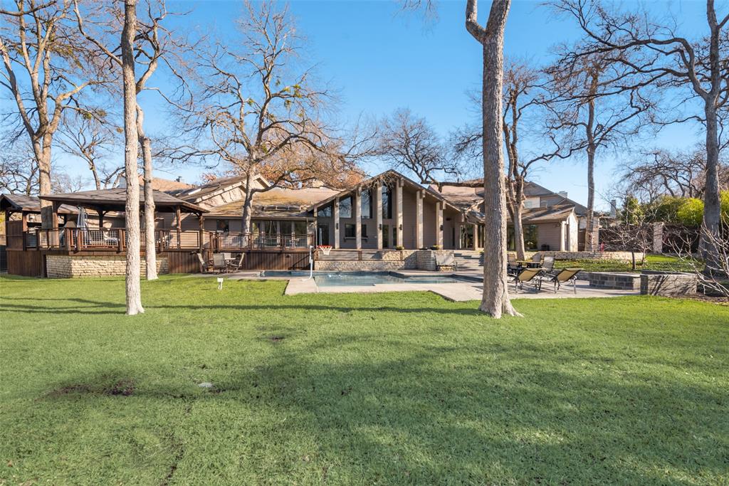 Private Estate property on heavily wooded half acre creek lot backing to greenbelt. Fantastic natural light throughout the home with sweeping views of the professionally landscaped and terraced yard. Primary suite is split with sitting area overlooking back yard, 2 separate offices, and 2 massive closets and remodeled bathroom including 2 separate sinks and counters, shower dual heads and seat. Main living area with enormous fireplace and wet bar with ice maker and built in refrigerator for entertaining. Kitchen features built in SS refrig, double ovens, gas cooktop, walk in pantry, wood island and quartzite countertops and Butlers pantry.  Secondary bedroom on main floor off kitchen with ensuite bath. Guest and Pool half bath accessible from backyard. Travertine tile and hardwood floors throughout. Upstairs 3 bedrooms and 3 baths. Backyard features include pool and spa, covered outdoor living area, new roof 2024, new fence 2020, backyard lighting, tree and pillar lights. Gated.