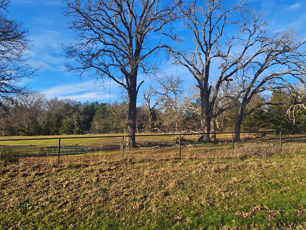 1.25-acre custom home lot, located within the city limits of Greenville, TX. Conveniently situated just south of I-30, this property combines accessibility with serenity. The flat terrain is ideal for building, while a few stately oak trees add natural beauty and character. Already equipped with a driveway and gate, the lot also features durable pipe fencing on three sides for added privacy and charm. Neighboring lots are available if you desire even more space to create your perfect retreat.