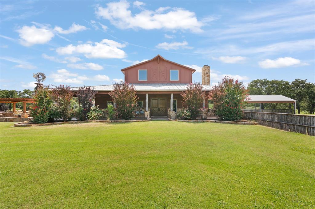 Welcome to a true Texas retreat where rustic charm meets resort-style living. Nestled on expansive, picturesque 30 acres  in the Cleburne, this extraordinary custom estate blends the warmth of a luxury lodge with the convenience and style of modern country living.
From the moment you enter the gated drive, you’ll be captivated by the inviting barn-style architecture with metal roofing and wide wrap-around porches designed for entertaining and relaxation.
Inside, the home is a showcase of craftsmanship and design, boasting soaring wood-paneled ceilings, rich hardwood floors, and hand-selected rustic finishes throughout. The open-concept great room with a dramatic stone fireplace flows seamlessly into the gourmet kitchen, equipped with high-end appliances, custom cabinetry, and a massive granite island perfect for gatherings plus a large walk in pantry and separate formal dining area .  
A beautiful staircase leads to an upstairs loft and primary suite with stone accents , freestanding tub and a closet that is everyones dream .The bedroom opens out to a balcony where you can enjoy your morning coffee while admiring this gorgeous property.  Downstairs there are  spacious bedrooms and spa-inspired baths that provide comfort and style. This home is also nudura insulated and has a room that can serve as a safe room as well.   Whether you’re curling up by the fire, entertaining by the pool, or taking in the panoramic views from your porch, this home delivers an unmatched lifestyle.
 The showstopping backyard features a sparkling, lagoon-style pool complete with rock waterfall, tanning ledge, and elegant landscaping—anchored by a custom windmill feature and stone water tower that adds authentic ranch character. There is also a 50x100 workshop with a 30x80 overhang with 4 large roll up doors plus a man cave upstairs .   Call today to schedule an appointment to see this gorgeous property.
