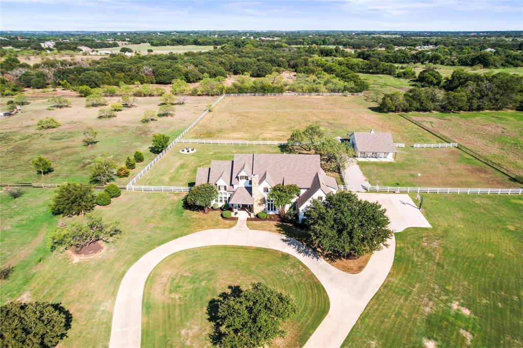Luxury Meets Country Living on 5 Stunning acres in Argyle ISD***Welcome to your dream estate, perfectly nestled at the end of a peaceful cul-de-sac in one of North Texas' most desirable communities. Located within the award-winning Argyle ISD and close to Liberty Christian School, this remarkable 5-bedroom, 5.5-bathroom residence blends refined luxury with serene country living.***Step through the grand entry into a home designed to impress—featuring soaring cathedral ceilings, a spacious office, and a chef’s kitchen outfitted with high-end appliances and designer finishes throughout. The open floor plan flows seamlessly to the oversized 3-car garage, which includes 2 Tesla Powerwall battery banks for energy resilience.***Enjoy first-floor living with both the Primary suite and a full in-law suite conveniently located downstairs. Two fireplaces provide warmth and elegance, while the upstairs offers additional spacious bedrooms, media room and extra living space.***Outdoors, the amenities are equally exceptional: a resort-style pool with a waterfall, slide, and hot tub; an expansive covered patio with an outdoor kitchen; and a 3-stall horse stable inside a 2-story drive-thru barn, complete with a side carport ideal for RV or extra vehicle storage. The home is powered by a 12 kW solar system, ensuring modern efficiency. ***Whether you're hosting large gatherings or enjoying peaceful sunsets over your private acreage, this home delivers unparalleled style, space, and sustainability.  Come take a tour today and experience the modern, country, luxury living yourself.