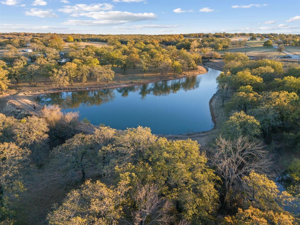 Discover the Ultimate American Dream: Your Private Texas Family Oasis on 33+ Acres
Picture golden Texas sunrises over your 60,000 sq. ft. spring-fed private lake—ideal for kayaks, trophy bass fishing, or quiet shore-side coffee as ducks glide by. This is the American Dream: vast spaces, freedom, self-sufficiency, and family legacy in Wise County’s serene countryside along Hwy 199. 33+ acres of pristine, fully fenced cross-fenced pasture—no restrictions, outside city limits. Supports horses, cows, emus; perfect for chickens or any livestock. Minutes from Fort Worth, yet peacefully secluded. Beautifully updated 3-bed, 2-bath ranch home set back amid mature trees for privacy. Open-concept living with stunning chef’s kitchen: custom cabinetry, premium appliances, flowing to living room for gatherings and memories. Oversized primary bedroom retreat: sitting area, coffee-wine bar, luxurious shower, dual closets. Oversized laundry room—a true luxury—with washer dryer for effortless chores and organization. Outside: 32x32 fenced turf yard (dog owner’s paradise for safe play), covered parking, grand gated entrance. Farther back: spacious man camp with power and water in its own fenced enclave—perfectly positioned to overlook the private shooting range—ideal for extended family stays, hunting buddies, grown kids boomeranging home, or conversion to extra living quarters. Crown jewel: magnificent private lake for paddleboards, canoes, picnics, exceptional fishing, bonfires. On-property hunting for deer, dove, waterfowl—great for teaching kids outdoor traditions—plus your private shooting range for safe, convenient practice and recreation. Build your homestead: raise animals, produce hay, hunt, fish, shoot, enjoy freedom. Room for pools, arenas, gardens, guest homes, playgrounds, dog agility. Legacy property where generations (and dogs) thrive. More than land—independence and family bonds. Dream homestead awaits. Rare—won’t last. Buyer verify. Claim your Texas dream today.