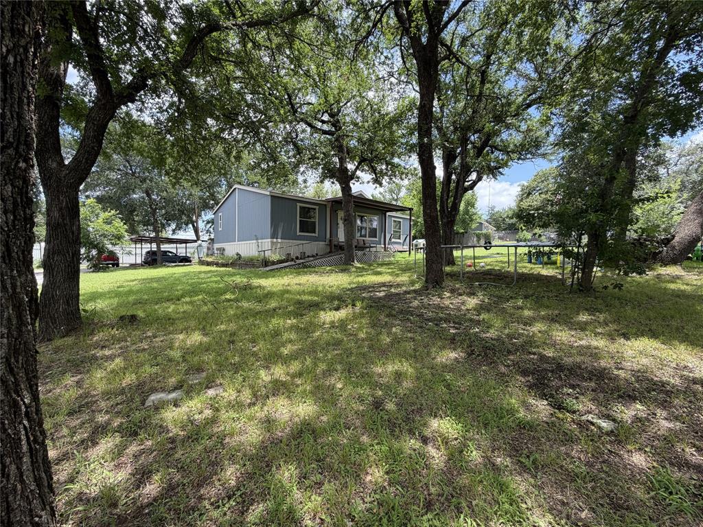 Looking for peaceful country living with room to spread out—without giving up convenience? This beautifully updated 2022 doublewide mobile home sits on nearly half an acre just outside the city limits, offering the perfect blend of privacy, comfort, and accessibility. Featuring 3 spacious bedrooms and 2 full bathrooms, this move-in-ready home has been thoughtfully updated with new flooring, fresh paint, and new carpet, creating a bright and inviting atmosphere throughout. The open-concept layout is ideal for both everyday living and entertaining, with plenty of space for family and friends to gather,  Step outside and enjoy the large backyard patio, perfect for summer barbecues, family celebrations, or simply relaxing and taking in the peaceful surroundings. The generous lot provides ample parking and plenty of room for outdoor activities, gardening, or future improvements, added bonus of 1 RV Space, Conveniently located in a quiet neighborhood with quick access to Loop 820 and Downtown Fort Worth, you'll enjoy the tranquility of country living while remaining close to shopping, dining, schools, and major employers.  As an added bonus, a full-price offer includes the refrigerator, washer, dryer, range, microwave, automatic gate opener, and security cameras—making this an incredible value and truly move-in ready!  Affordable, updated, and packed with extras, this property offers an opportunity you don't want to miss. Schedule your private tour today and discover why this home is the perfect place to put down roots!