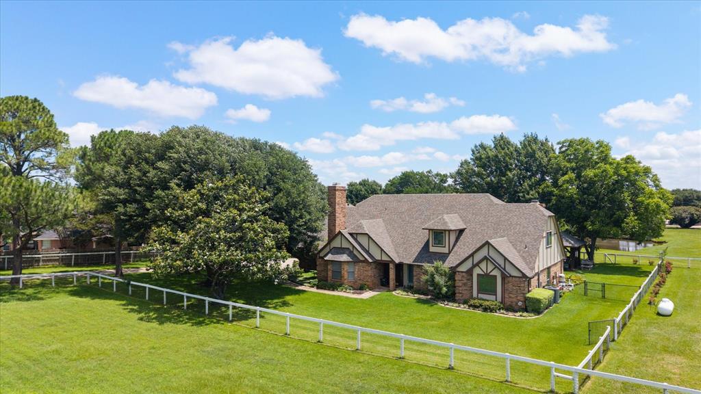 Exceptional versatility for entertaining and multi generational living awaits on nearly 4 acres in Mansfield ISD. 
The two story home features 4 spacious bedrooms, 4 full bathrooms, and 1 half bath, along with an attached epoxy coated 2 car garage. A flexible bonus space provides endless possibilities as a craft room, game room, home gym, or can easily be converted back into a third garage bay.
Inside, you'll find generous living spaces designed for both everyday living and entertaining, including two living areas with beautiful hardwood floors, a formal dining room, an upstairs home office, and an inviting eat in kitchen featuring solid wood cabinetry. The second floor also features a finished out temperature controlled cedar closet, providing exceptional storage and organization. The primary suite serves as a private retreat, complete with its own fireplace and a luxurious ensuite bath featuring a garden tub, separate shower, and dual vanities. Step outside and discover your own backyard oasis. The resort style outdoor living area includes a large diving pool, gazebo, covered patio, outdoor kitchen, and expansive entertaining space perfect for hosting family and friends year round. The picturesque pond, highlighted by a lighted fountain, adds beauty and tranquility to the property. Equestrian enthusiasts and hobbyists alike will appreciate the barn, which features a dedicated tack room with a separate entrance, two roll up doors, two horse stalls.  There is also cross-fencing throughout the property.
Additional upgrades include granite countertops, plantation shutters, three HVAC units, two electric privacy gates providing separate entrances with the front gate being camera monitored, and a new roof installed in 2025.