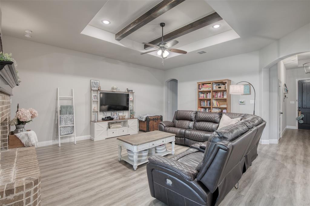 Step into this beautifully designed 4-bedroom, 2-bathroom home that blends charm, warmth, and modern style. The inviting open-concept layout features a stunning kitchen complete with granite countertops, a large island, and stylish decorative lighting, all flowing seamlessly into the living area. A dedicated dining area sits just off the kitchen, creating an ideal space for gatherings and everyday meals. The spacious living room is highlighted by a large brick fireplace and wooden beams along the ceiling that add striking design and character. Beautiful vinyl flooring in entry, kitchen, dining and living room. Previous owners converted the tandem garage into extra storage with convenient access from inside the home. This is definitely a must-see home offering comfort, style, and timeless appeal.