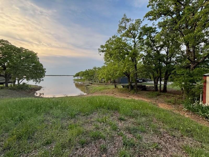 Waterfront lot ready for your dream home,   Or enjoy for the time being in your RV with two RV hookups already in place.  Improvements include: pipe fencing, recent water well and septic system set up for your RV's or ready to hook into  your new lake house, storage building already in place.   Information on approved dock construction for this property can be provided by the City of Nocona.