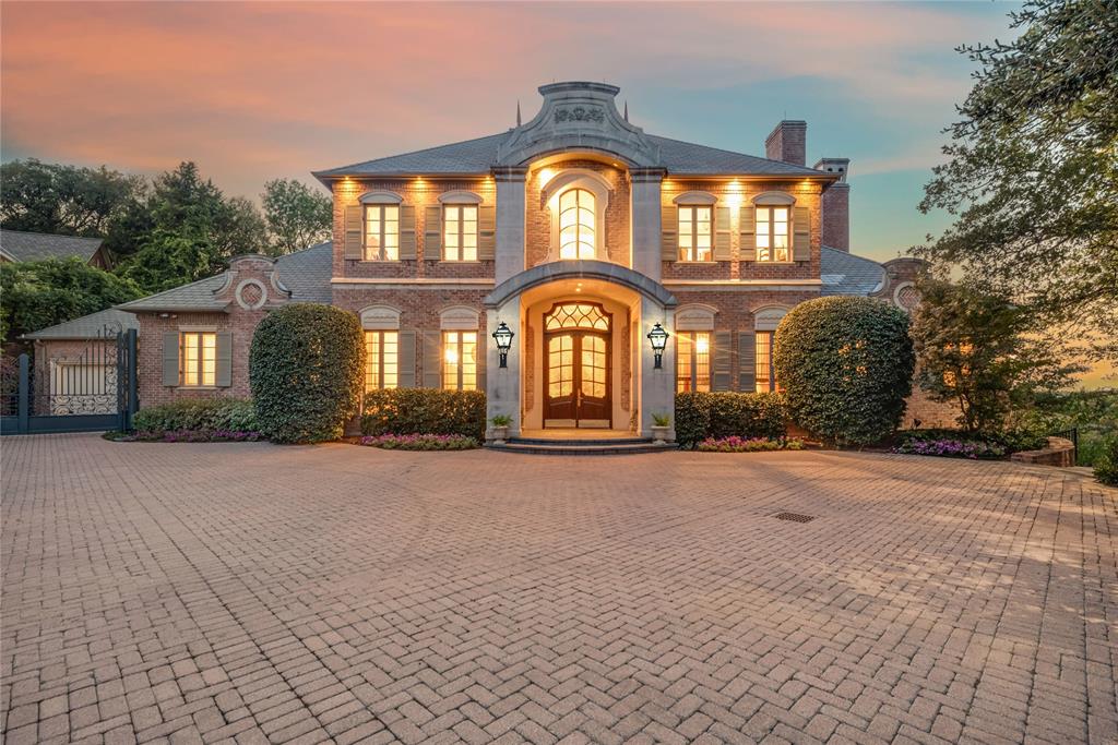 Ideally positioned in the heart of Arlington, home to FIFA World Cup 2026 events at AT&T Stadium, this offers an exceptional opportunity to own luxury real estate in one of North Texas' most internationally recognized destinations. This masterpiece was conceived as a French château, shaped by European architectural influence and designed for lasting comfort. Many of the home’s architectural elements were sourced from Europe and installed first, with the structure designed around them, giving the residence a collected, timeless presence. Set on two wooded acres along the West Fork of the Trinity River, the property offers rare privacy while remaining equidistant to Downtown Dallas and Fort Worth. Winding trails lead to the water’s edge, while the rear of the home overlooks Lake Viridian. The residence spans 9,026 square feet across three levels, with an additional 835 square feet of flexible upper-level space, all served by an elevator. The main living areas are climate controlled by a geothermal system, with traditional HVAC serving the garage and flex space. The main level features a grand entry with Versailles-inspired flooring, sweeping iron staircase, and crystal chandelier. A central parlor opens through imported French château doors to the veranda and is anchored by a Louis XIV limestone fireplace. The formal dining room, wet bar, office with Regency-era fireplace and London post-office doors, chef’s kitchen with a separate catering kitchen, and a private primary suite with dual baths and custom closets complete the main floor. The pool level includes a full kitchen, wine cellar, game or studio space, laundry, and direct access to the resort-style terrace. The upper level offers three bedrooms, two baths, catwalk views, and a balcony suite overlooking the estate. A rare blend of European architecture, privacy, and location in the heart of North Texas.