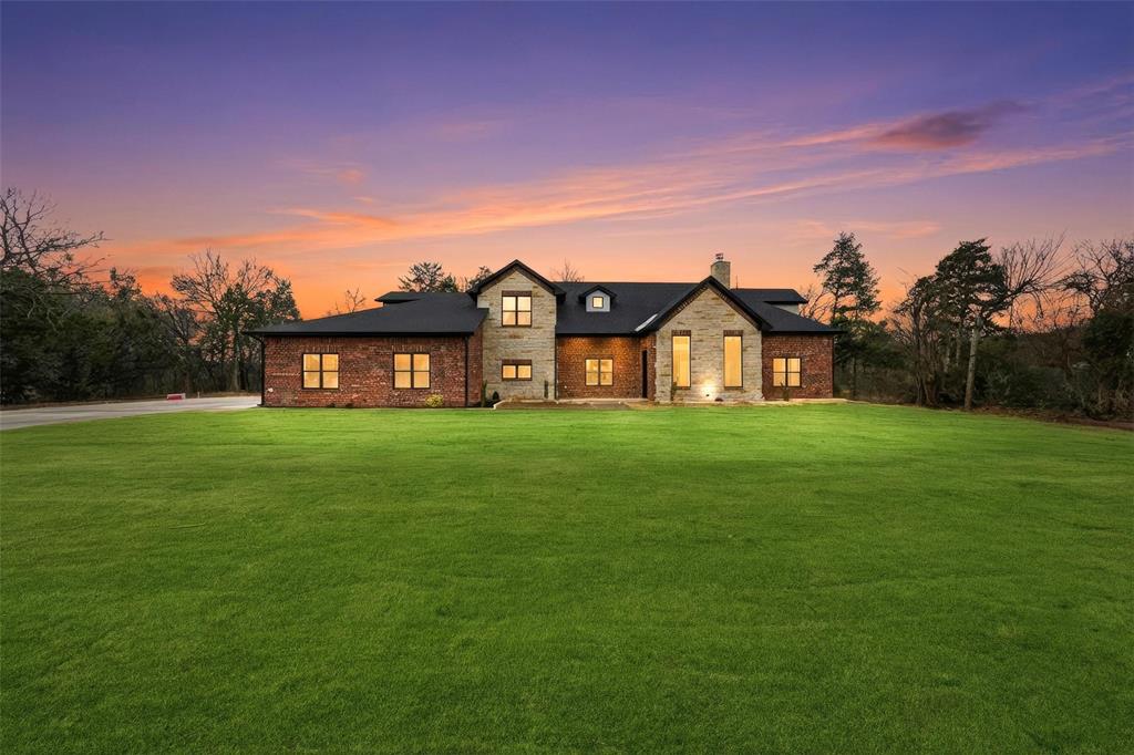 Located in a quiet cul-de-sac on just over 2 acres, this spacious 5-bedroom, 4.5-bath home offers privacy, generous space, and a well-designed setting. The property features a long concrete driveway, providing a welcoming approach and ample parking, along with open acreage that enhances both privacy and usability. Inside, the home showcases hardwood flooring, high ceilings, and a bright, open layout designed for comfortable everyday living. The main living area features a fireplace, creating a warm and inviting focal point. The kitchen is thoughtfully designed for both function and entertaining, featuring Quartzite countertops throughout, handmade inset Shaker cabinetry, a large center island, stainless steel appliances, and custom tile finishes. A built-in mud area and spacious utility room add convenience and practical organization. The primary suite offers a private retreat with dual vanities, a soaking tub, an expansive walk-in closet, and a luxurious custom shower. Secondary bedrooms are generously sized and provide flexibility for a variety of needs. The second level includes additional living space and a private balcony patio overlooking the surrounding acreage, offering elevated views and a quiet outdoor escape. The backyard is designed for enjoyment and entertaining, featuring a stamped concrete patio with an outdoor grill, ideal for gatherings and relaxation. The home is also pre-wired for a speaker system, adding modern convenience. A rare opportunity to enjoy spacious country-style living with modern comfort and functional design. Buyer and buyer’s agent to verify all information, including measurements, schools, and features.