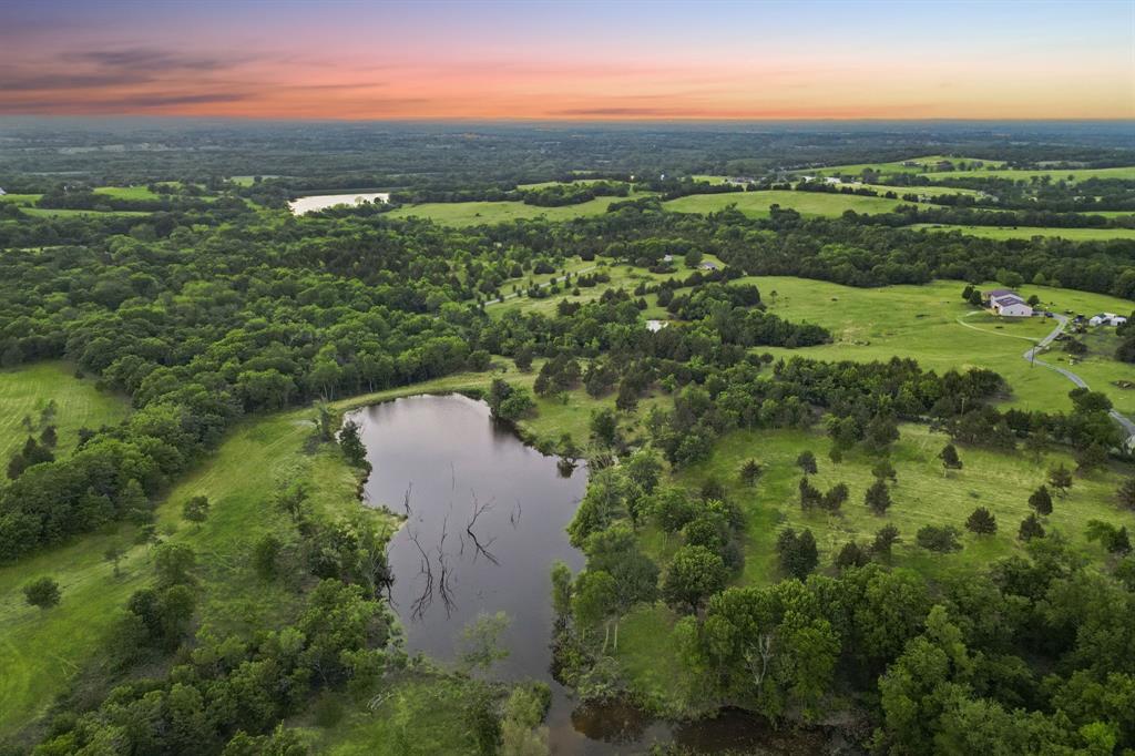 Discover 109+ acres of picturesque countryside with miles-long, panoramic views from a commanding hilltop — the ideal build site for your dream home or private retreat. This tranquil property offers endless potential for farming, recreation, hunting, or fishing.  A once in a lifetime opportunity to own a bucolic piece of Texas countryside that supports abundant wildlife and offers multiple internal sites for homes, barns, or pastures. There are no restrictions, allowing flexible use and development. Gently rolling and varied topography is lush with abundant trees for privacy and two idyllic ponds teeming with fish and visited regularly by waterfowl. Prime development opportunity as Seller holds a will-serve letter for approximately 70+ water meters — a rare utility benefit for large-scale development or multi-site use.  With access to property from a scenic paved road between Sherman and Bells, the tract is minutes from HWY 56, HWY 82, HWY 11, and HWY 75 for easy commuting. Minutes to downtown Bells, Texas - a small, peaceful town known for it's friendly atmosphere and rural charm.  Don’t miss this rare opportunity to own a private, versatile acreage with spectacular views and excellent access.