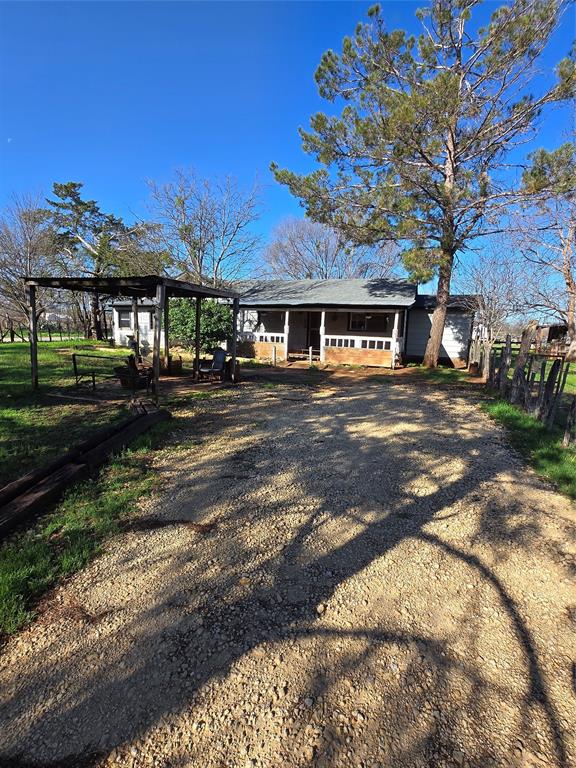 This unique property spans almost an entire city block and offers endless potential. The 1,350 sq. ft. rustic home features four bedrooms and one bath, full of character and country charm. Mature shade trees surround the residence, creating a peaceful private retreat right in town.

The property includes multiple outbuildings—a workshop, storage areas, and a chicken coop—ideal for hobby farming or home-based projects. A covered carport provides convenient parking, and the on-site shop offers plenty of space for tools or business use.

Whether you’re looking for room to grow, space to work, or a little taste of the country with city convenience, this property delivers a rare combination of size, versatility, and old-fashioned charm.

There is an additional vintage mobile home on the property that could be turned into an additional residence for rental.