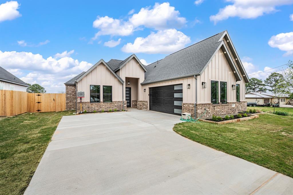Welcome to 806 N Ave E in Springtown. Custom 4-bedroom, 2.5-bath home situated on an oversized 14,427 sq ft lot with ample space for a pool, workshop, or future ADU. Approx. 2,093 sq ft living and 2,959 sq ft under roof.

Open-concept floorplan with 11 ft ceilings, 8 ft doors, recessed ceilings in entry hallway and primary suite, and durable LVP flooring throughout. Ceiling fans installed in every room and on the covered back patio. Spacious living area features a 72” electric fireplace. Private primary suite includes a 70” electric fireplace.

Kitchen offers oversized island, custom cabinetry with trash bin and spice pullouts, walk-in pantry, double ovens, built-in microwave, 5-burner electric cooktop with pot filler, and Calacatta quartz countertops extending to backsplash, windowsills, and bay window seating.
Primary bath includes glass walk-in shower, stand-alone soaking tub, and large walk-in closet. Full utility room with sink and mudroom with built-in bench.

Extended covered patio with lighting, ceiling fan, and LED wafer lighting. Exterior also features LED downlights under soffit and fascia. Large garage with automatic opener. Electric tankless water heater and full gutter system installed.

Functional design with upgraded finishes on a large lot in a growing area.