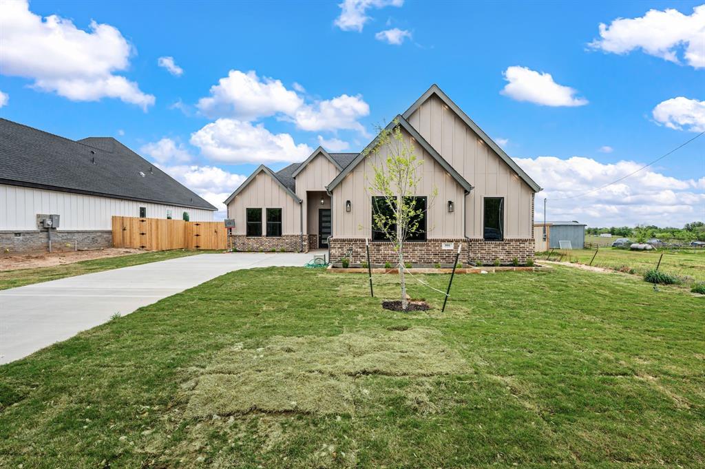 Welcome to 806 N Ave E in Springtown. Custom 4-bedroom, 2.5-bath home situated on an oversized 14,427 sq ft lot with ample space for a pool, workshop, or future ADU. Approx. 2,093 sq ft living and 2,959 sq ft under roof.

Open-concept floorplan with 11 ft ceilings, 8 ft doors, recessed ceilings in entry hallway and primary suite, and durable LVP flooring throughout. Ceiling fans installed in every room and on the covered back patio. Spacious living area features a 72” electric fireplace. Private primary suite includes a 70” electric fireplace.

Kitchen offers oversized island, custom cabinetry with trash bin and spice pullouts, walk-in pantry, double ovens, built-in microwave, 5-burner electric cooktop with pot filler, and Calacatta quartz countertops extending to backsplash, windowsills, and bay window seating.
Primary bath includes glass walk-in shower, stand-alone soaking tub, and large walk-in closet. Full utility room with sink and mudroom with built-in bench.

Extended covered patio with lighting, ceiling fan, and LED wafer lighting. Exterior also features LED downlights under soffit and fascia. Large garage with automatic opener. Electric tankless water heater and full gutter system installed.

Functional design with upgraded finishes on a large lot in a growing area.