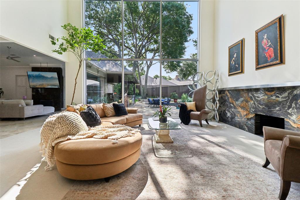 Nestled on an expansive lot in the prestigious guard-gated community of Harbord Oak Estates, this custom Bob Thompson estate offers an exceptional blend of luxury, privacy, and timeless design. Perched beneath a canopy of mature trees, the grand entry makes a striking first impression with stately iron-and-glass double doors. Inside, expansive living spaces are bathed in natural light and adorned with high-end finishes, including floor-to-ceiling windows that frame breathtaking views of the outdoor sanctuary. Designed for both relaxation and entertaining, the backyard showcases lush landscaping with fruiting trees, a PebbleTec heated pool with a waterfall feature, a stone seating area, an outdoor kitchen, and a large grassy lawn—creating a serene retreat that feels worlds away. Indoors, elegance continues with a dramatic room-length bookmatched exotic granite fireplace surround,  soft neutral tones, and warm stone accents anchoring the main living area. The luxurious primary suite is a private haven featuring Venetian plaster walls and a spa-inspired bathroom with custom cabinetry with Blum soft closing hardware, 6cm granite, a walk-in double shower with body sprays, and a Jerusalem stone soaking tub filled from above. A thoughtfully designed custom closet offers extensive built-ins, an island with storage and display lighting. Perfect for hosting, the home includes a central wet bar, wine storage, a secondary living space with an Italian fossil stone fireplace, and a spacious chef’s kitchen. Upstairs, a large game room and spacious ensuite bedrooms provide comfort and privacy for family or guests. Additional highlights include updated window glass (2025), a Class IV impact-resistant roof, a 3-car garage, an in-ground basketball goal, and private trail access leading to White Rock Creek for outdoor enjoyment. Zoned for Plano Schools and ideal location with a convenient drive to downtown Dallas, dining and entertainment.