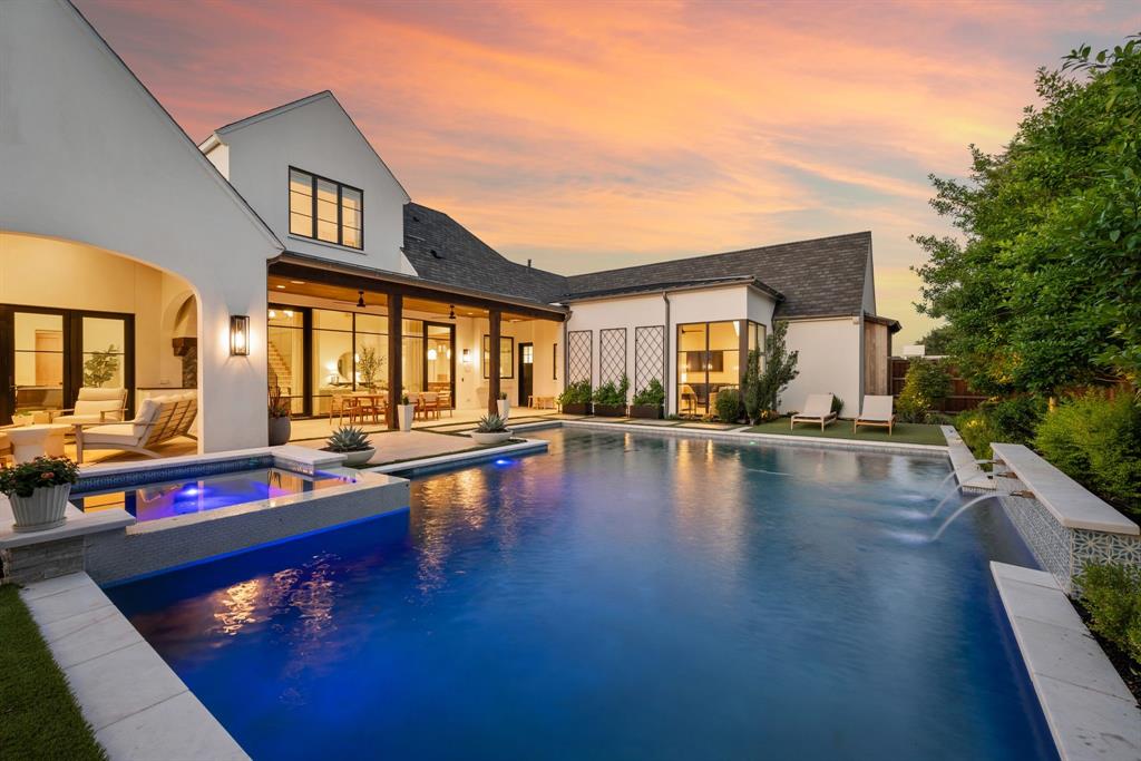 Some homes just feel different the moment you step inside- where every detail is intentional. Built in 2022 and nestled in the heart of Southlake, this home is equal parts showpiece and sanctuary. The kitchen is a standout, combining everyday function with elevated design, anchored by a waterfall-edge marble island and wrapped in floor-to-ceiling cabinetry. A white oak coffered ceiling adds architectural warmth, while a fully equipped butler’s pantry offers additional prep and storage space for seamless entertaining.
The open-concept living areas feature vaulted ceilings with wood beams and expansive wall-to-wall windows and doors that blur the line between indoors and out. Just beyond, the covered patio hosts an outdoor kitchen, a fireplace lounge, and views of a sparkling pool and spa, creating a magazine-worthy backyard oasis. Downstairs, a dedicated entertainment room with a full bar provides the perfect setting for game nights or movie marathons and opens directly to the patio for effortless indoor-outdoor flow.
The master suite is tucked away for privacy and bathed in natural light, with views of the pool and spa. A guest suite is also conveniently located on the first floor. Upstairs, a large playroom and a second laundry room offer additional flexibility and function. Throughout the home, arched walkways, layered textures, and soft neutral tones create a calming, grounded atmosphere. Even the office feels intentional- moody, built-in, and perfectly positioned. Located in Southlake with open enrollment to Carroll ISD, this is a home wrapped up in timeless design.
OPEN ENROLLMENT TO CARROLL ISD