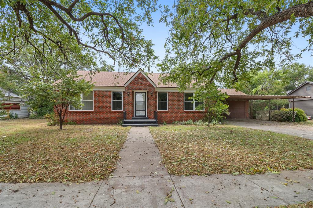 Completely remodeled and move-in ready, this 4-bedroom, 2-bathroom brick home with 2,090 sq ft offers the perfect combination of classic charm and modern updates. The exterior features timeless brick with white trim, white siding accents on the back, a brand-new composition roof, and all new windows. Two towering shade trees in the front yard welcome you home, while an attached two-car carport adds convenience.
Step inside the front door to the cozy living room, where rich hardwood floors, natural wood plank walls, built-in cabinets, and an electric fireplace with mantle create a warm and inviting space. From here, three roomy bedrooms branch off, each filled with natural light from generous windows and offering nice-sized closets. A guest bath in the hallway includes a tub and shower combination, single-sink vanity, and built-in shelving.
The dining room, also with hardwood floors, flows directly into the beautifully updated kitchen. Designed with farmhouse-chic style, the kitchen features butcher block countertops, soft green wood cabinetry, and included appliances—electric oven, dishwasher, sink, and refrigerator. Just beyond, a charming sunroom with concrete floors, a brick accent wall, and a wall of windows overlooks the spacious backyard.
The sequestered master suite addition is a true retreat, with a large bedroom, vinyl flooring, and an en-suite bath boasting dual sinks and a walk-in shower. A large laundry room provides plenty of space for full-size appliances and additional storage.
The backyard is fenced with chain link and dotted with mature trees and shrubs, perfect for pets, play, or outdoor gatherings. Located in an established neighborhood with alleys, this home is just minutes from schools, the hospital, and downtown Coleman. With Coleman’s thriving small-town charm and easy 3-hour commute to several metroplex cities, this property is the perfect place to enjoy Small Town, Big Life.