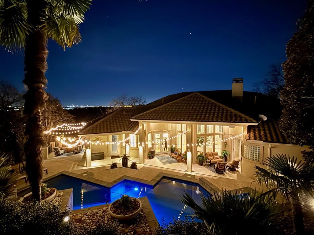 Commanding wide-open views from a scenic hillside setting, this one-of-a-kind custom residence by Bailey Draper is a true move-in-ready masterpiece. Offering sweeping panoramic vistas and timeless architectural elegance this remarkable home is located within the award-winning Grapevine–Colleyville ISD and perfectly positioned between Dallas and Fort Worth with effortless access to DFW International Airport. Just minutes from Historic Downtown Grapevine and Southlake Town Square, world-class shopping, dining, and entertainment are always close at hand. Set on over half an acre, the property seamlessly blends modern sophistication with everyday comfort. An impressive entry welcomes you into a light-filled interior where rich hardwood floors extend throughout the open-concept main level. Soaring ceilings, expansive terraces, and walls of windows create a stunning backdrop and bathe the home in natural light. The formal study and dining room open directly to outdoor terraces, offering effortless indoor-outdoor living. At the heart of the home, the gourmet kitchen is a chef’s dream, featuring a built-in refrigerator, gas cooktop, stainless steel appliances, quartz countertops, and an oversized island. The private primary suite is a true sanctuary, complete with balcony access and a dramatic see-through fireplace leading into a spa-inspired bath with a jetted tub and glass-enclosed shower. Designed with entertainment and convenience in mind, the home includes a game room, media room, and kitchenette, all accessible via elevator. Generously sized secondary bedrooms provide comfort and privacy, while a versatile fifth bedroom—currently used as a fitness room—features a walk-in closet and en suite bath. Outdoors, a covered patio overlooks the sparkling pool and attached spa, complemented by an outdoor fireplace for year-round enjoyment!