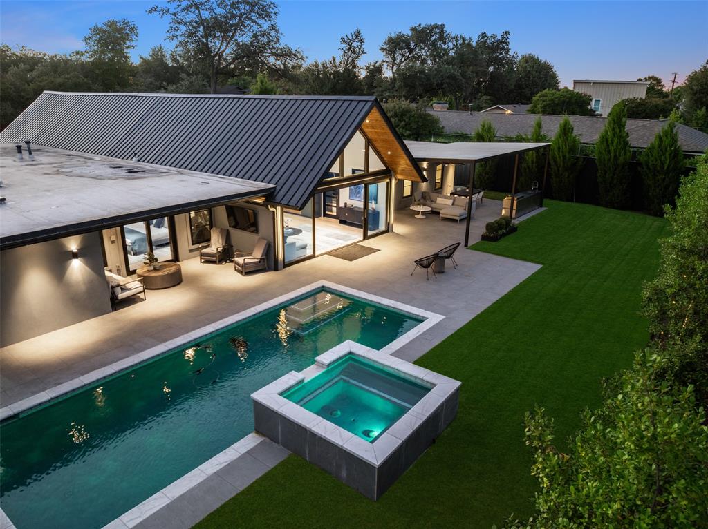 A striking blend of contemporary architecture and California-inspired design, this fully reimagined luxury residence showcases high-end craftsmanship, seamless indoor-outdoor living, and resort-style amenities throughout. A dramatic gallery-style entry opens to an expansive great room with soaring ceilings, wide-plank white oak floors, and oversized windows that flood the home with natural light. Designed for both everyday living and elevated entertaining, the open-concept layout centers around a sculptural waterfall-edge marble island in the chef’s kitchen, complete with a full Thermador appliance suite including a gas cooktop, double ovens, dual sinks, and dual dishwashers. Sleek custom Florense cabinetry from Brazil adds modern sophistication, premium storage, and designer finishes throughout the kitchen and primary suite. Floor-to-ceiling designer tile elevates each bathroom with a spa-inspired aesthetic and bespoke modern detailing. The luxurious primary retreat features dual custom closets with Florense built-ins, creating a refined balance of beauty and functionality. Three oversized sliding glass doors provide seamless access to two covered patios, a fully equipped outdoor kitchen, and a private backyard oasis with a sparkling resort-style pool, ideal for entertaining and year-round indoor-outdoor living. Thoughtfully curated with premium materials, expansive entertaining spaces, luxury finishes, and warm modern design, this exceptional residence offers the perfect combination of architectural sophistication, comfort, and California-style luxury living.