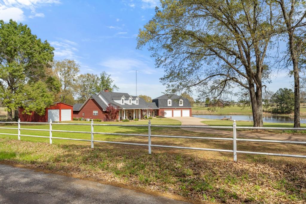 A gated, ag-exempt estate on 12 acres with a 3 acre stocked fishing pond, extensive updates, and pricing belowrecent appraisal. Located in Flint, this property offers land, quality construction, and long term value. Appraised in February 2026 at $1,320,000 and priced below appraisal, this ag exempt estate offers privacy, function, and careful upkeep throughout. The home includes approximately 3,485 square feet with 4 bedrooms and 3.5 baths, multiple living areas, andflexible spaces for daily living and entertaining. Above the garage is an additional 950 sqft bonus room. The remodeledchef's kitchen features custom cabinetry, granite countertops, Monogram gas range and microwave, dual trash drawer, andtile backsplash. The living area includes a custom faux stone fireplace with bespoke mantle and a ventless gas log system. Updates include solar tubes, updated lighting, fresh paint, and new flooring. The primary suite includes an updated bath withrock walk in shower with three shower heads, granite counters, updated cabinetry and sinks, a freestanding tub set on rock flooring, and a ceiling fan. Guest baths feature tile walk-in showers, granite counters, copper sinks, and updated fixtures. The bonus room has a sink and counter space, a bathroom, sealed wood stairs, and offers flexible use as a private guest or mother-in-law suite. Outdoor features include a covered wood deck, flagstone walkways, a bridge over a seasonal creek, native East Texas landscaping, fruit trees, and berry plantings. A stocked almost 3-acre fishing pond with lighted dock and windmill aeration anchors the setting. Established Purple Martins provide natural insect control. Additional improvements include a 24x40 metal shop on slab, 1200 sqft walkout basement with workshop, new roof and gutters, new window screens, replaced ceiling fans, three new water heaters, sunroom roll up shades, security gate and alarm system, and an approximately 490 foot water well. Call for a showing today!