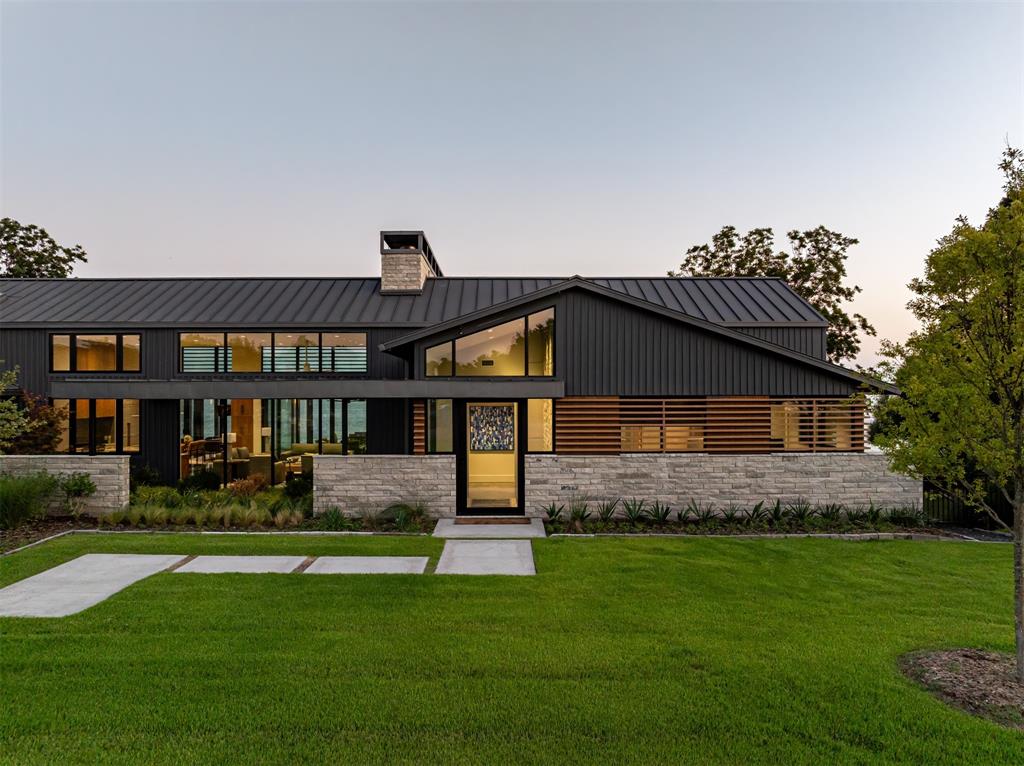 This contemporary masterpiece sits on a premier water front lot at Paradise Point in The Shores. From the moment you enter the front atrium, designer lighting sets the tone for a breathtaking experience. This home features 4 bedrooms (including a 4 bed bunk room) & 4.5 baths, a chef's style kitchen, dog exercise space, butlers pantry, beverage bar, & panoramic views of the lake through wall to wall glass & sliders. The primary suite provides a spa like ensuite bath & sitting area with expansive walk-in closet and built in storage. Custom built & meticulously designed with indoor outdoor resort style living in mind complete with fireplace, electric patio shades and exquisite landscape design that compliments the space. Luxury finishes like Quartzite surfaces, Thermador appliances, custom lighting & hand crafted cabinetry flow throughout the home. The low maintenance TREX boathouse features boat lift & jet ski lifts to get you straight out onto the lake from 195 ft of water frontage.