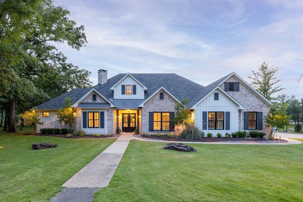 A rare opportunity to own one of the largest waterfront estates in the prestigious Pinnacle Club on Cedar Creek Lake. Offered together as 201 and 203 Sandpiper Drive, this exceptional property spans more than 3.3 acres and boasts approximately 340 feet of shoreline, creating a unique combination of luxury, privacy, and future potential. The custom residence at 201 Sandpiper Drive was thoughtfully designed for both grand entertaining and relaxed lake living, featuring 5 bedrooms plus a bunk room, 6 baths, a bonus room, resort-style pool, private boathouse, and dock. Inside, soaring vaulted ceilings with exposed wood beams, expansive windows, designer finishes, and a stunning floor-to-ceiling brick fireplace create a warm and elegant atmosphere. The chef's kitchen features premium appliances, custom cabinetry, and an oversized porcelain island designed for gathering. The luxurious primary suite includes a spa-inspired bath with heated floors, while double washers and dryers, three hot water heaters, smart-home wiring, a whole-home water filtration system, and a whole-home generator provide exceptional comfort and convenience. Expansive sliding glass doors seamlessly connect the interior to the spectacular covered outdoor living space complete with multiple seating and dining areas overlooking the pool and waterfront grounds. Enjoy direct access to boating, fishing and all that Cedar Creek Lake has to offer. Included in the offering is 203 Sandpiper Drive, an approximately 1.85-acre undeveloped waterfront parcel that contributes to the estate's impressive 304 feet of shoreline. Whether developed, sold separately, replatted with the existing homesite, or preserved for privacy, the possibilities are endless. Combining over 3.3 acres, extensive waterfront, luxury amenities, modern conveniences, and exceptional flexibility for future use, 201 and 203 Sandpiper Drive represent a once-in-a-generation opportunity to own one of Cedar Creek Lake's premier waterfront estates.