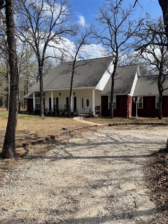 Unlike ANYTHING you've seen before, this property is truly serene and simply beautiful; it has forested and partially cleared areas where one can experience the aviary operas, squirrels, deer, bunny rabbits, and more, or sit on the covered front porch to enjoy a rainy day.

This well-maintained 3-bdrm, 2-bath home features a 2-car garage with room for loads of storage. The gated entrance, equipped with solar power & a back-up panel, leads to a spacious circular drive that also extends to the workshop and carport. New fencing encloses the entire perimeter. Inside, the welcoming foyer draws you into the formal dining room and to the custom kitchen that showcases granite countertops, pull-out drawers, under-cabinet lighting, two sinks, an island and abundant storage. The split floor plan provides privacy with a generous primary suite featuring a large master bath with a tub and separate shower and his and hers closets. Additional highlights include 2 other bedrooms, a RR, a breakfast nook, a large, flexible office space and a large utility room. The charm includes some pocket doors, tray ceilings, and a large brick fireplace with a propane starter for wood-burning ease in the living room. The well-insulated attic includes an electrically equipped bonus room - it's a great place for all your Christmas stuff!

Finally, the back of the home features a wooden deck that leads one to the great outdoors and to a substantial 20x30 workshop, equipped with electric, water, ceiling-mounted air hose reel, and an attached awning. Adjacent to the awning is a freestanding carport for additional parking. Also, you'll find several scenic nature trails, a gully and open, shaded areas that enhance this property's natural charm.

Ideally situated just minutes from Lake Whitney, the property offers convenient access to both Waco and DFW, placing it in a highly desirable area and blends comfort, functionality, and tons of natural beauty - perfect as your new home.