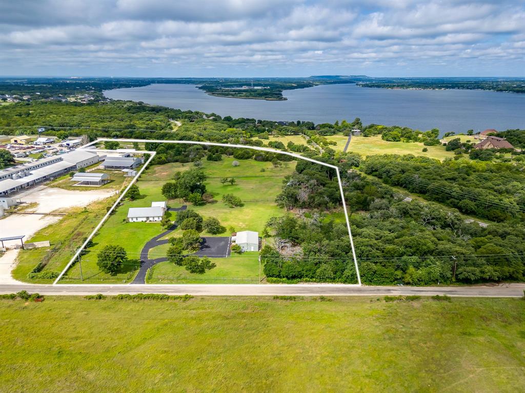 Rare 10 acre mixed use property offering exceptional combination of residential, commercial, & agricultural improvements just outside Granbury. Versatile property includes a 1455 SQFT HOME, 1200 SQFT OFFICE, shop, & barn, creating endless possibilities for business operations, live work flexibility, investment, hobby farming, equestrian pursuits, contractor headquarters, or equipment storage. The HOME features 3 bed, 2 bath, open-concept living, dining, & kitchen layout designed for comfortable everyday living. Vaulted ceilings create a spacious feel, while a large brick fireplace serves as the focal point of the living area. Neutral paint colors & flooring provide a move in ready interior. Kitchen is bright, functional & welcoming, spacious primary suite offers a private retreat. Screened in porch adds valuable year round living & entertaining space.  Separate 1200 SQFT OFFICE is ideal for a variety of business uses & includes reception & work areas, kitchenette, restroom facilities, storage space, metal construction, a low maintenance exterior, & extensive paved parking. The shop and barn add functionality and flexibility, while the open acreage offers room for expansion, livestock, equipment storage, recreation, or additional improvements. Properties that successfully combine residential living, business operations, and usable acreage are increasingly difficult to find in Hood County. Whether you're seeking a business headquarters, a live-work property, or a multi-use investment opportunity, this unique property delivers the space, infrastructure, and versatility to support a wide range of uses.